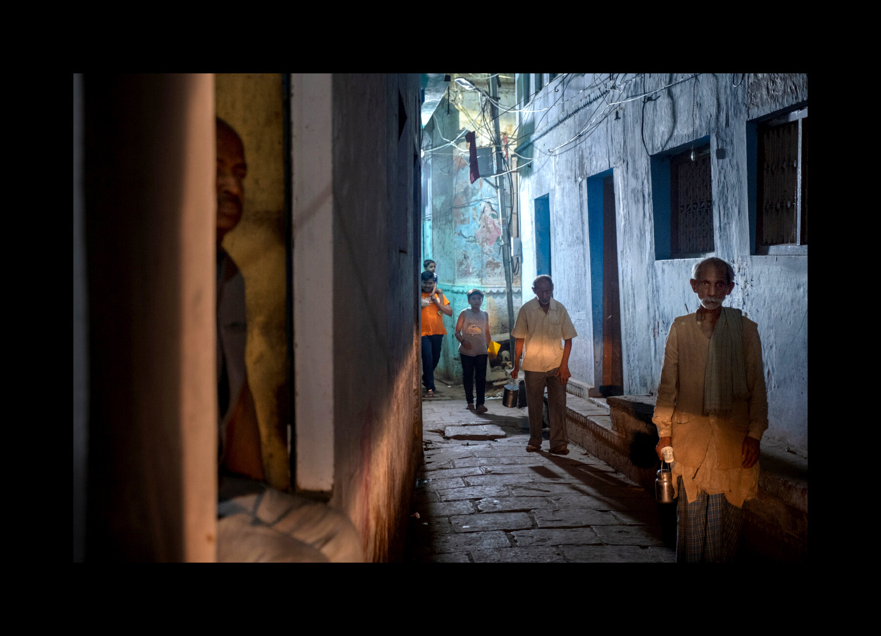  Locals walk home after a day of work in the old city of Varanasi, India. 2019 