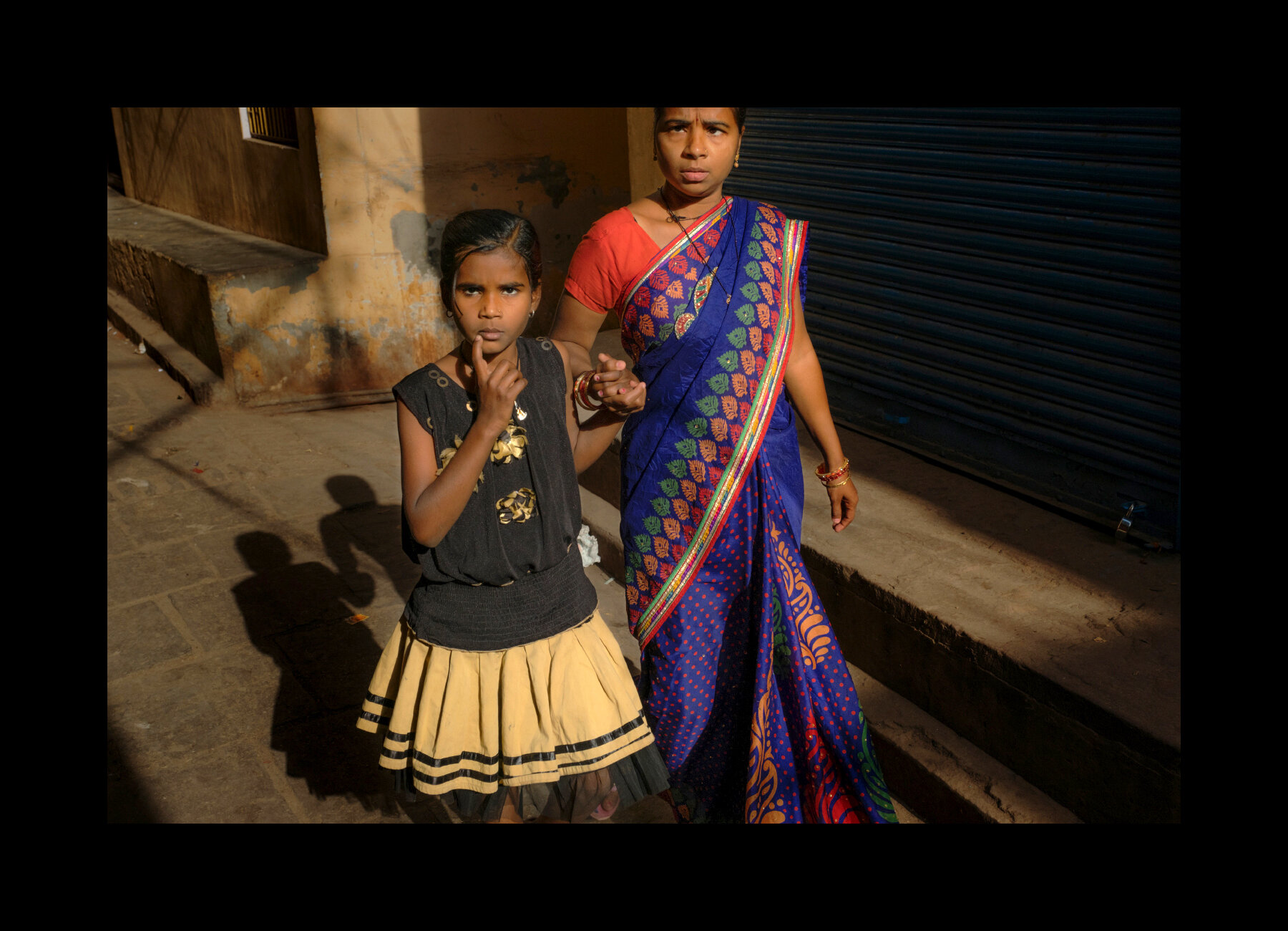  A mother and daughter walk together in the old alleyways of Varanasi, India. 2019 