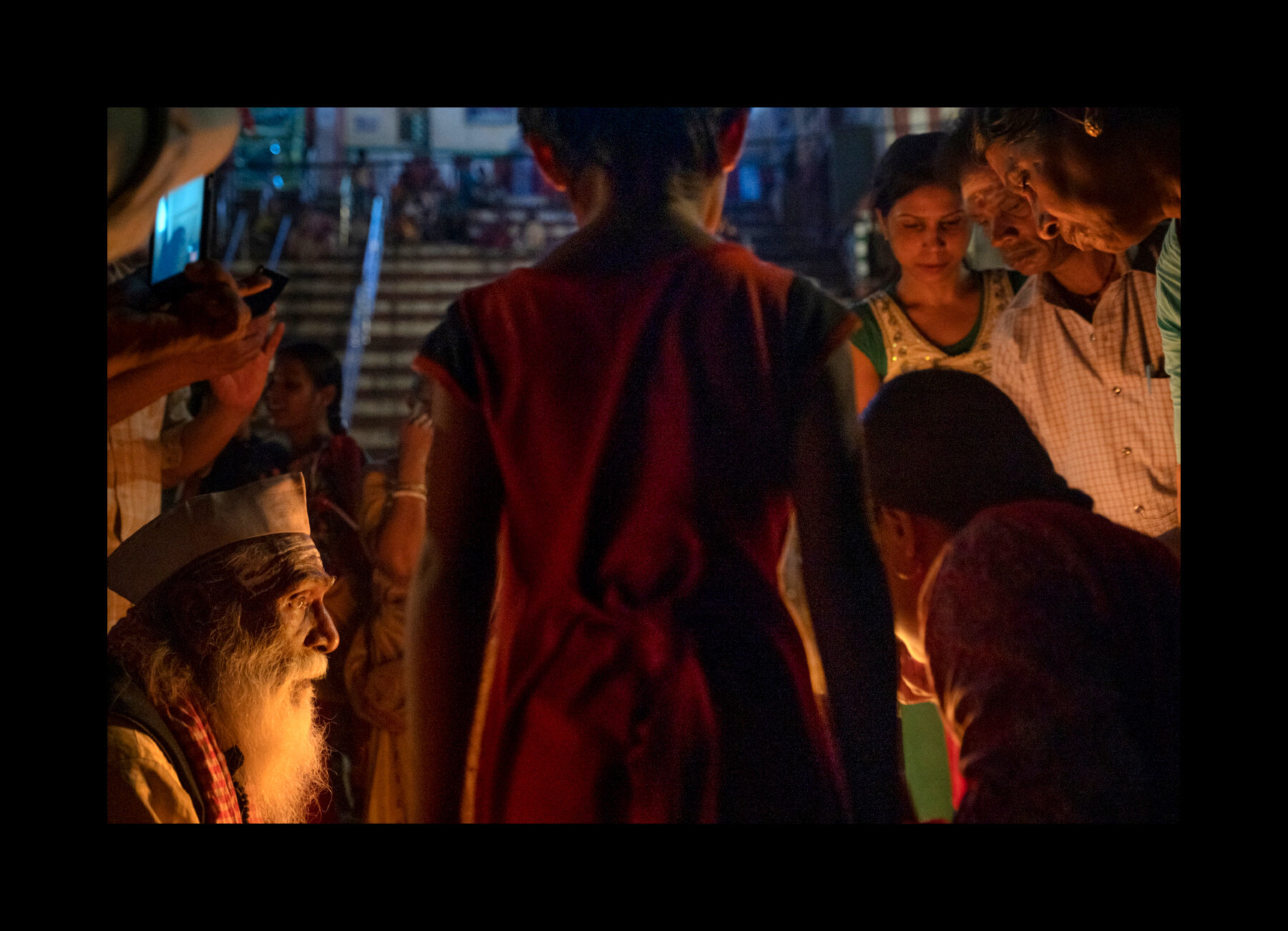  A sadhu tells stories to some local listeners along the ghats in Varanasi, India. 2019 