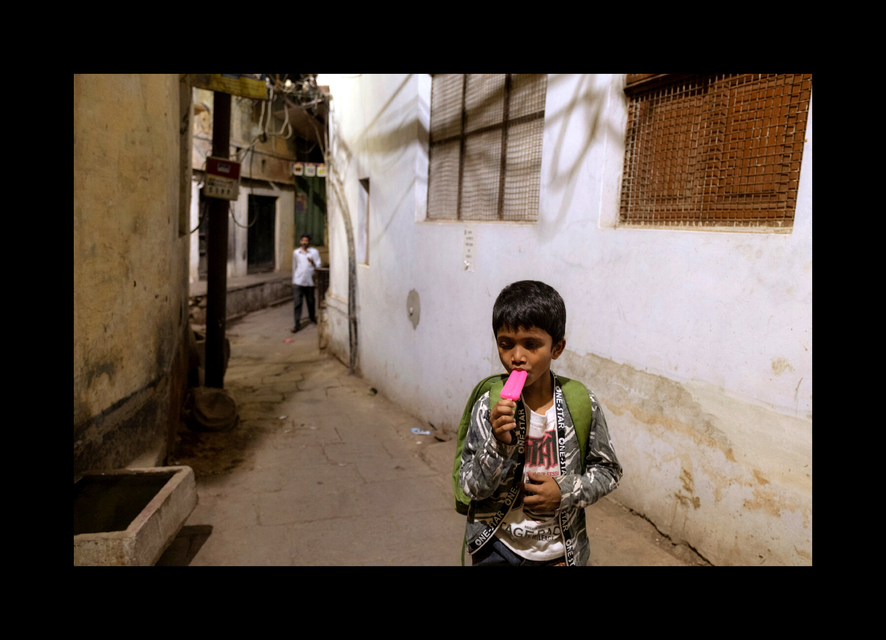  A young boy enjoys a refreshing popsicle after school in Varanasi, India. 2019 