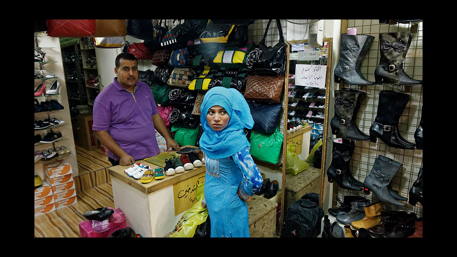  A teenager shops for clothes in a local shop in Mafraq. Jordan. The previous night, her family’s tent was robbed at gunpoint and all of their belongings were stolen. 2013 