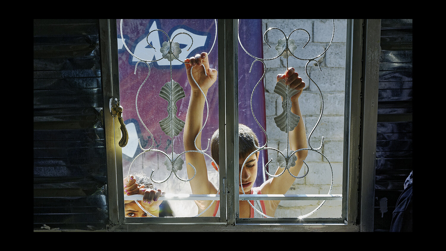  Refugee children peer in through the window at the International Medical Corps (IMC) facility in the Domiz Camp for Syrian Refugees near Dohuk, Iraq. 2013 