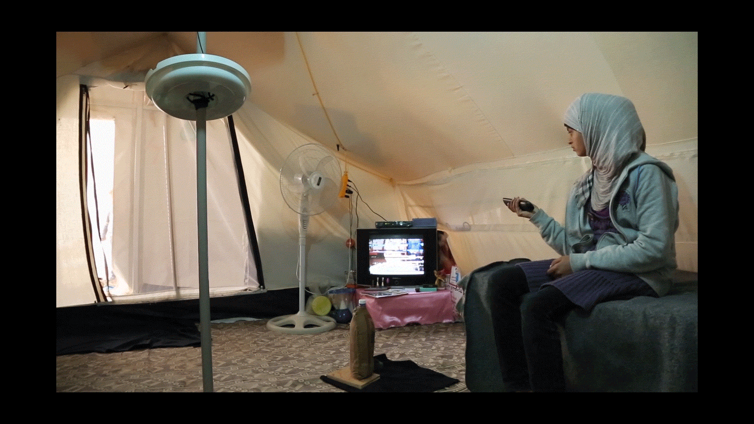  A teenager watches TV in her family’s tent at the Al Za'atri refugee camp for Syrians, near Mafraq, Jordan. 2013 