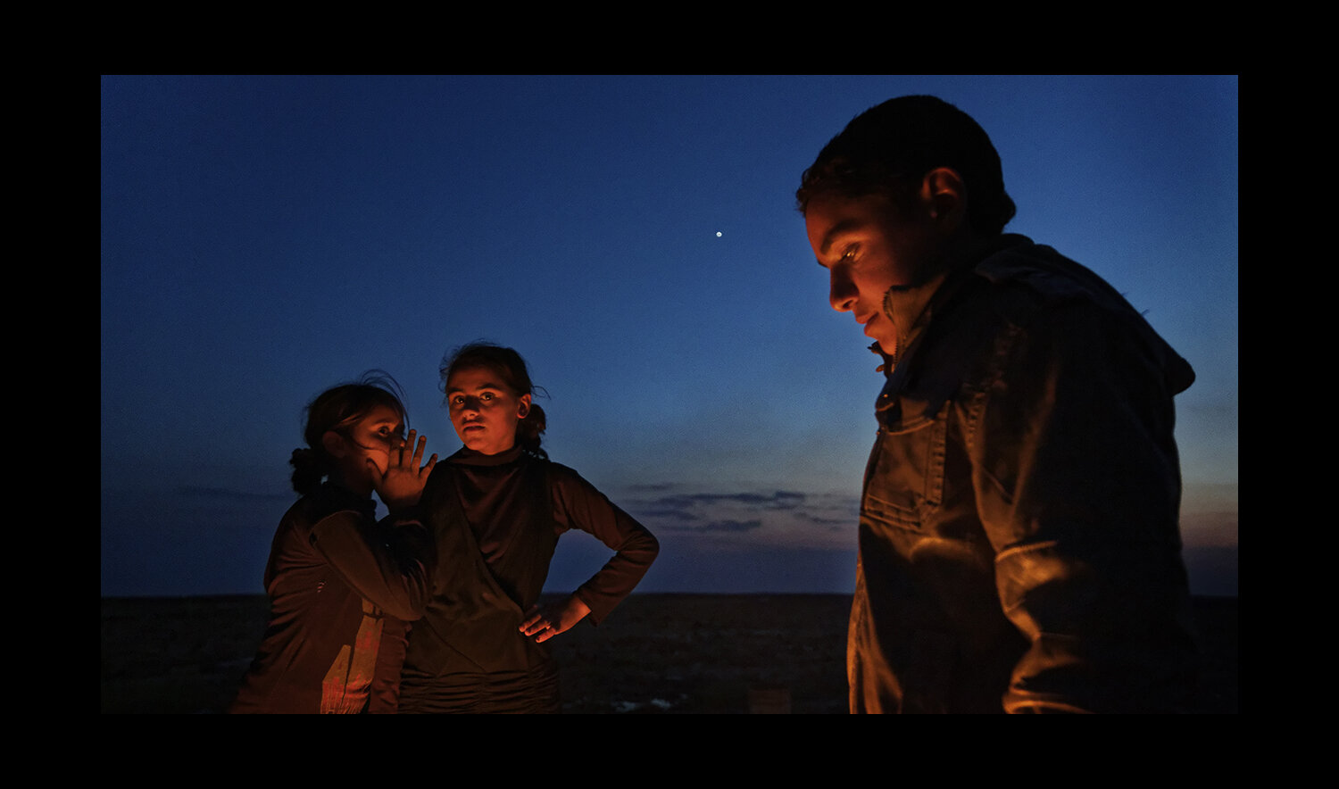  Refugee children gather by the fire in the middle of the desert between the Syrian and Iraqi borders in Ereinbeh, Jordan. 2013 