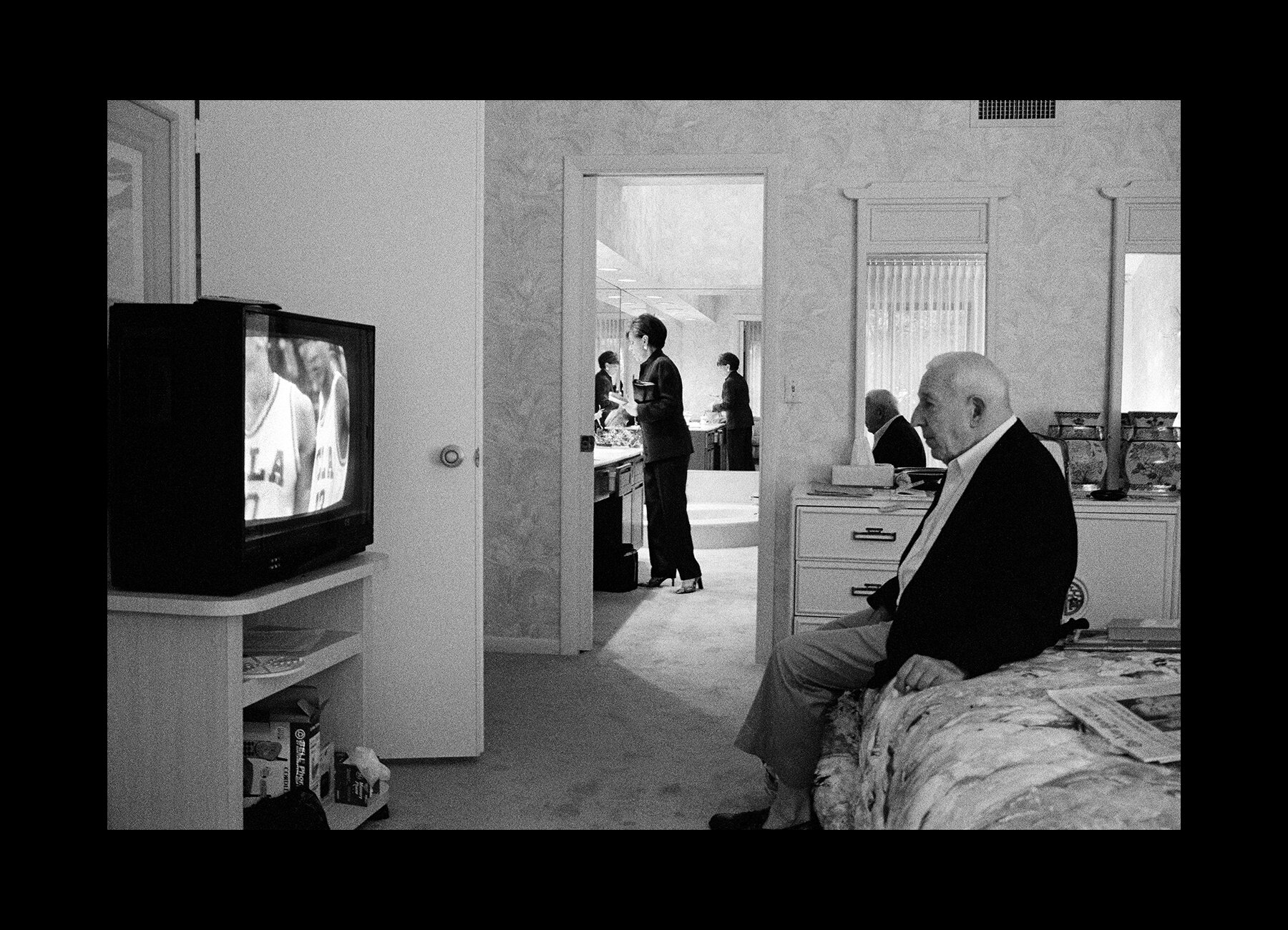  Herb Winokur watches basketball while his partner Ruth gets ready to go out in Delray Beach, Florida. 2001 