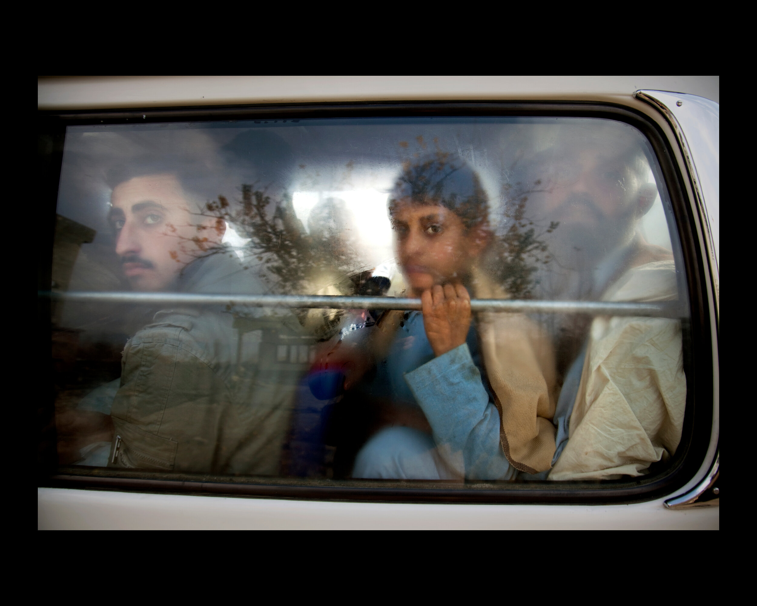  Peering through the glass, travelers await inspection at a Pakistani Army security checkpoint in Mingora and neighboring areas in the Swat Valley, Pakistan. 2009 