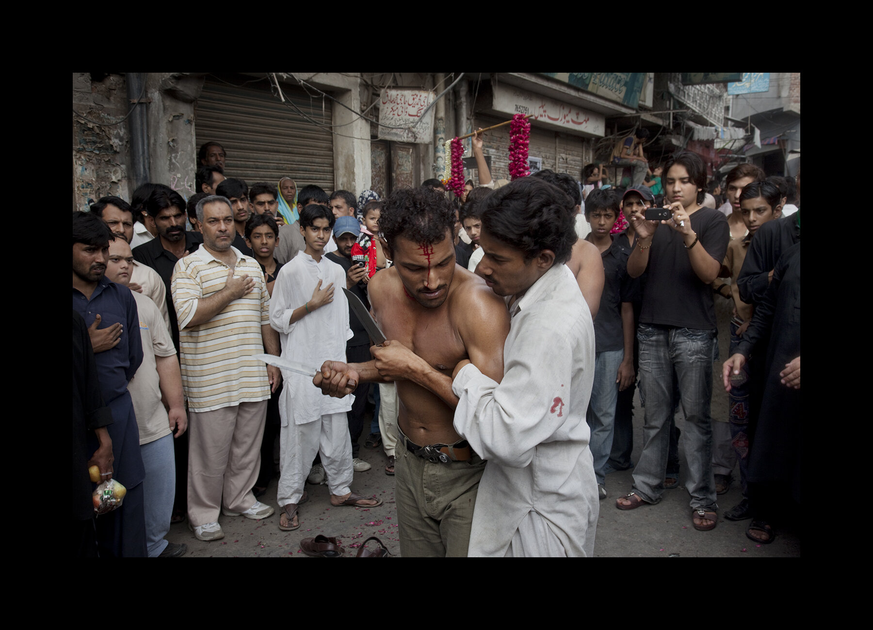  The Day of Ashura is on the 10th day of Muharram and is commemorated by Shia Muslims as a day of mourning for the martyrdom of Hazrat (Husayn) ibn Ali, the grandson of Muhammad.  In remembrance, Shi'as march through Lahore's Old City.  The men and b