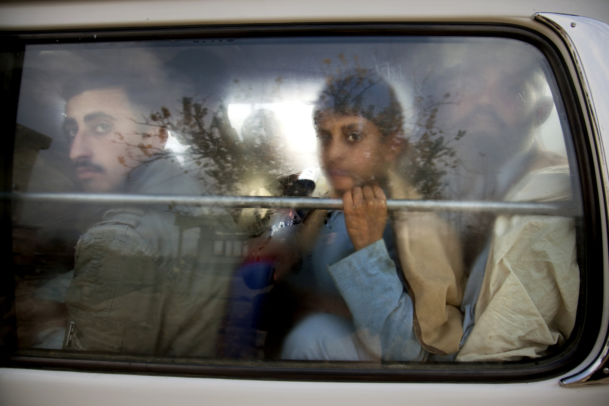  Peering through the glass, travelers await inspection at a Pakistani Army security checkpoint in Mingora and neighboring areas in the Swat Valley, Pakistan. 2009 