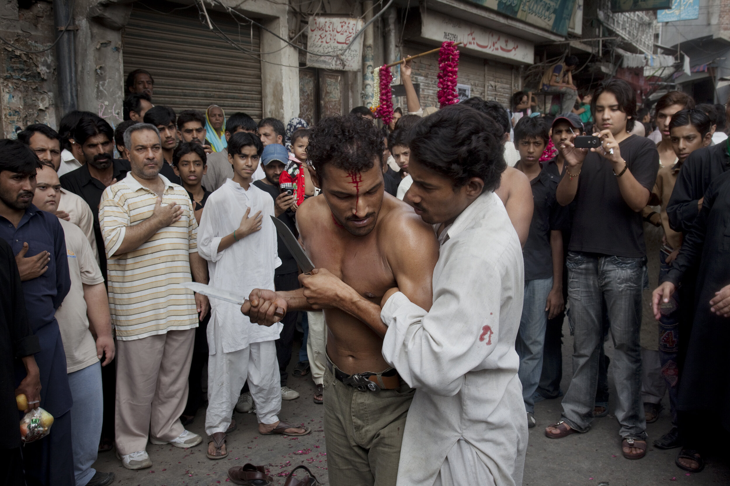  The Day of Ashura is on the 10th day of Muharram and is commemorated by Shia Muslims as a day of mourning for the martyrdom of Hazrat (Husayn) ibn Ali, the grandson of Muhammad.  In remembrance, Shi'as march through Lahore's Old City.  The men and b