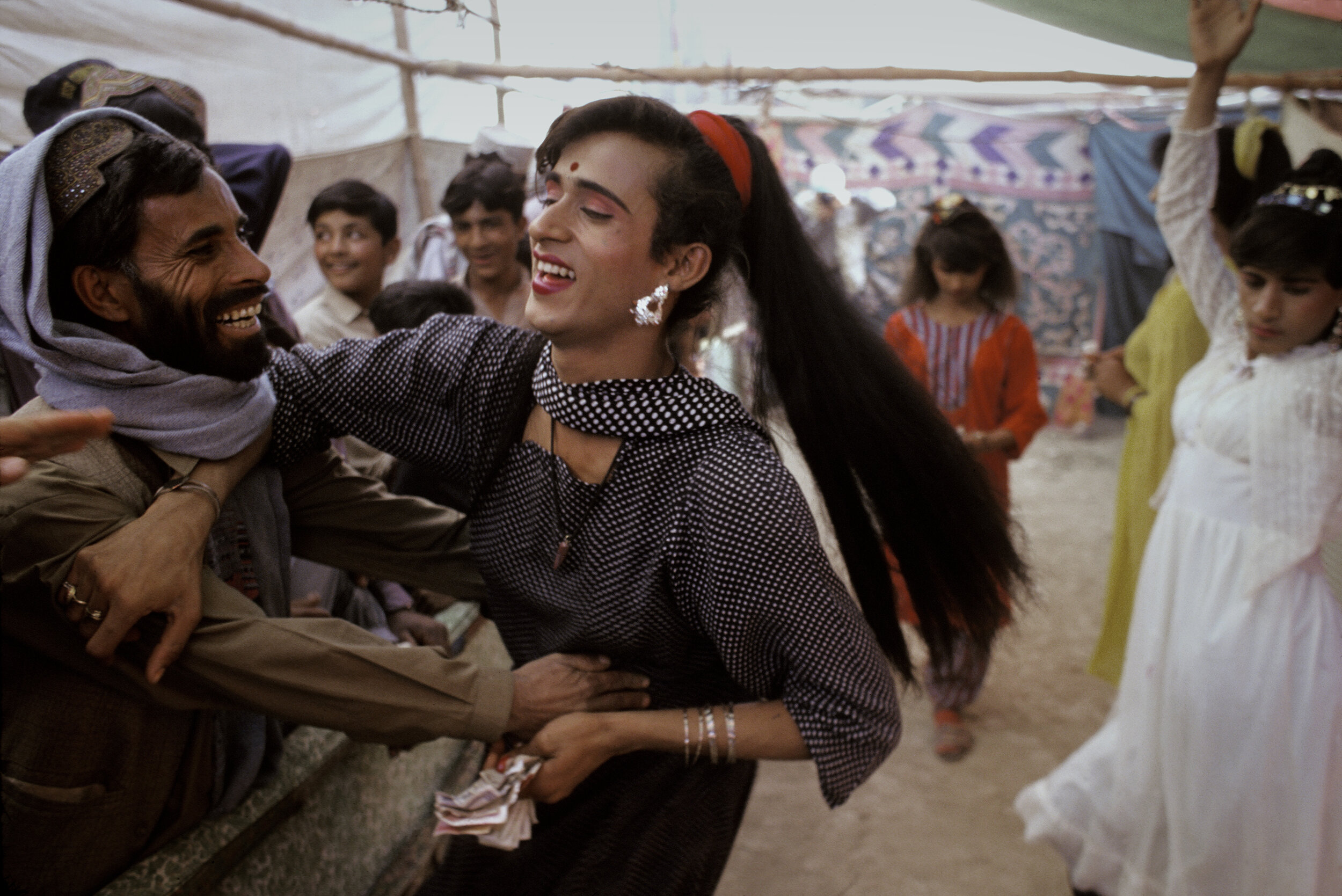  A trans person and onlooker are playful at the Sibi Mela Camel Festival in Balochistan, Pakistan. 1997 