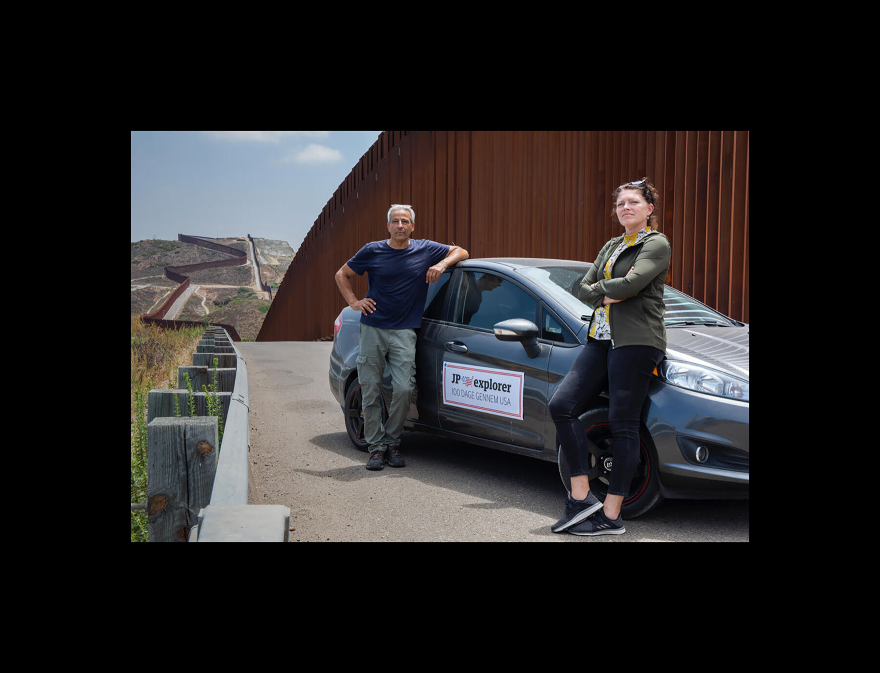  Photographer Ed Kashi and Journalist Heidi Plougsgaard Jensen pose with their Jyllands-Posten Explorer vehicle along the US-Mexican border wall near Chula Vista, California. 