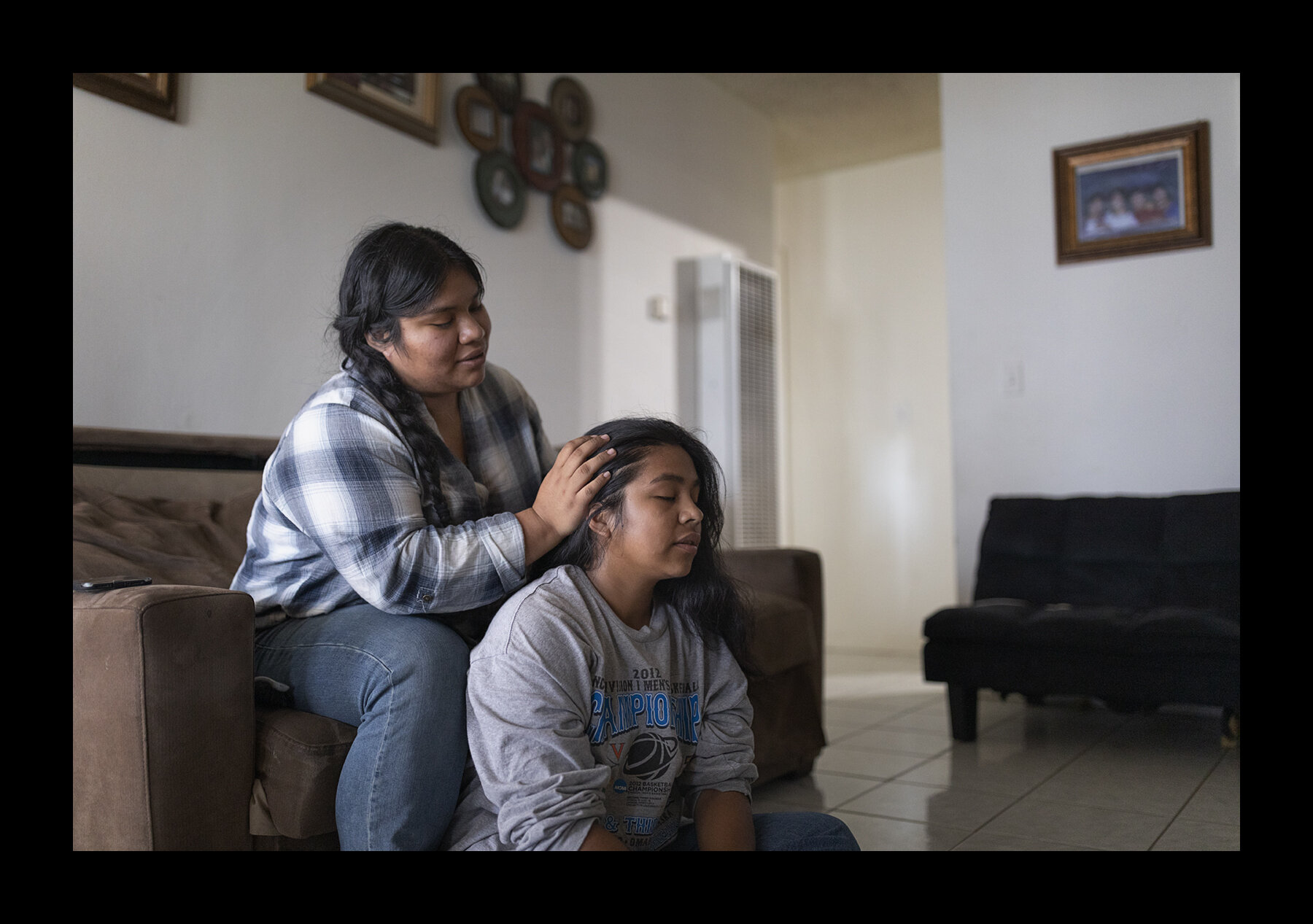  Barbara Perez, 18, braids her little sister Diana's hair at home in Oxnard, California. The sisters are both American citizens but their parents are undocumented. Their family used to have a flower stall at the local market and sold roses to tourist