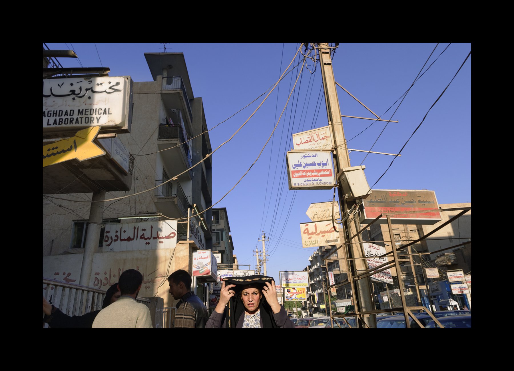    Baghdad, Iraq, 2003   A woman adjusts her veil as she walks through central Baghdad. 