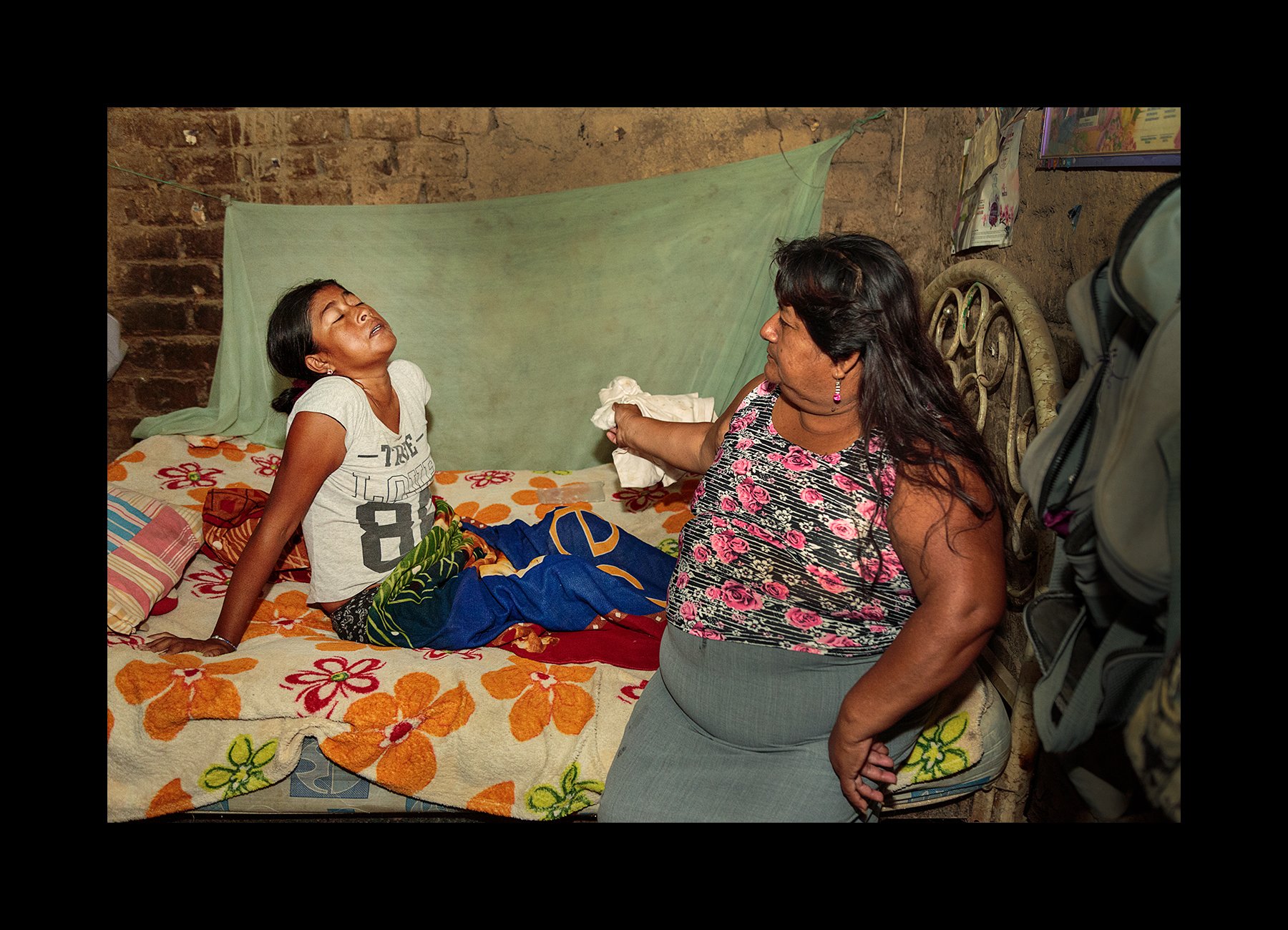  Mary Pacherres Alvarez, 32, at home feeling ill from an infection, while her mother cools her down in Ignacio Escudero Montelima on Feb. 12, 2018. 