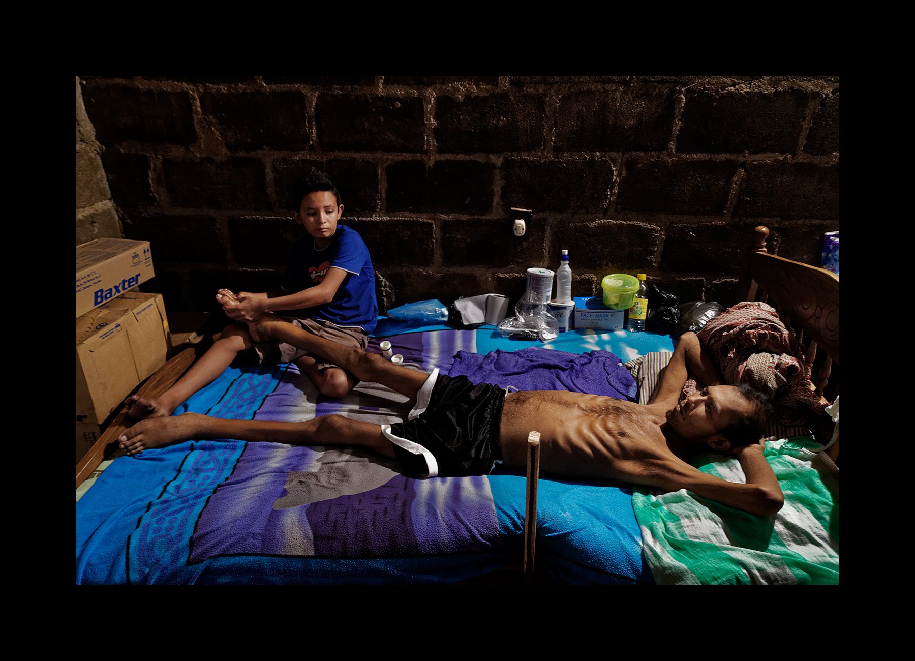  Cesar, 12, tends to his ailing father, Don Julio Lopez, 35, a former sugarcane worker, as he suffers through the end stages of CKDnT, in Chichigalpa, Nicaragua on Jan. 5, 2015. He worked for 15 years in the cane fields before getting sick. 