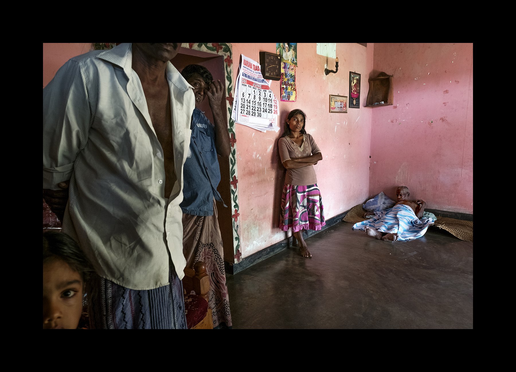  V. Aushadahami, 74, rests at home with family in Billewa, Sri Lanka on July 4, 2016. He was a rice farmer and has suffered from CKDnT for decades. He is now incapacitated and requires constant care by his family. 