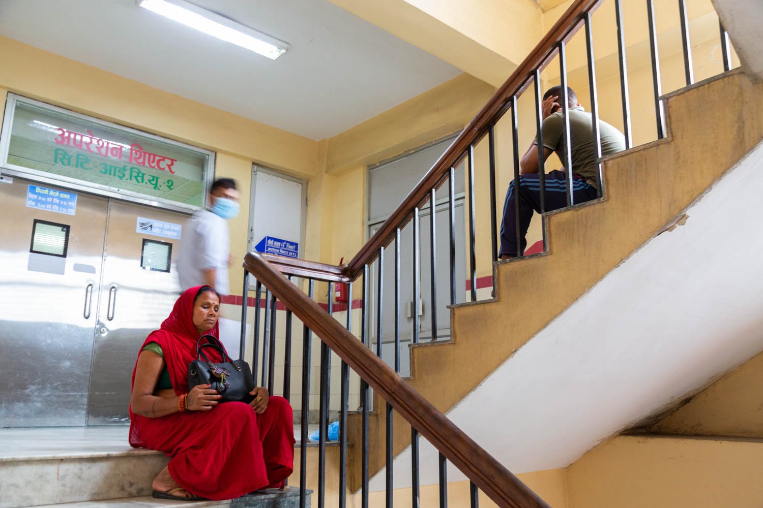  Visitors waiting in the stairwells and hallways in a hospital in Kathmandu, Nepal on June 27, 2022.  