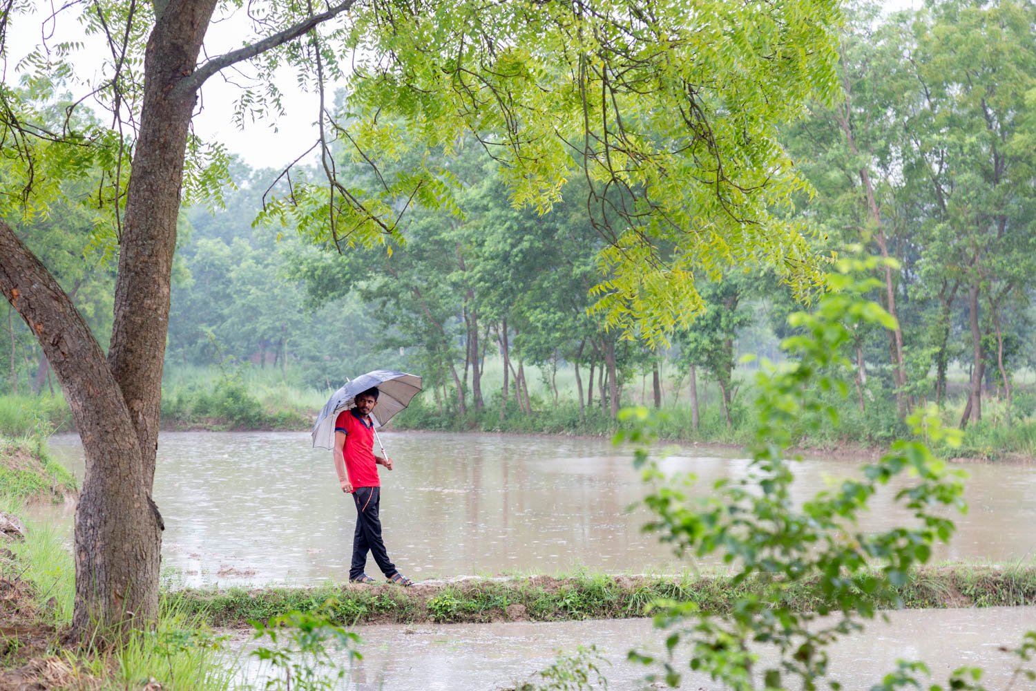  Indrajit Mandal, 22, holds an umbrella in the village of Nagrain 9, in the Ghodhas District outside of Janakpur, Nepal on July 1, 2022.  Mandal recently applied to work as an electrician in Qatar. 