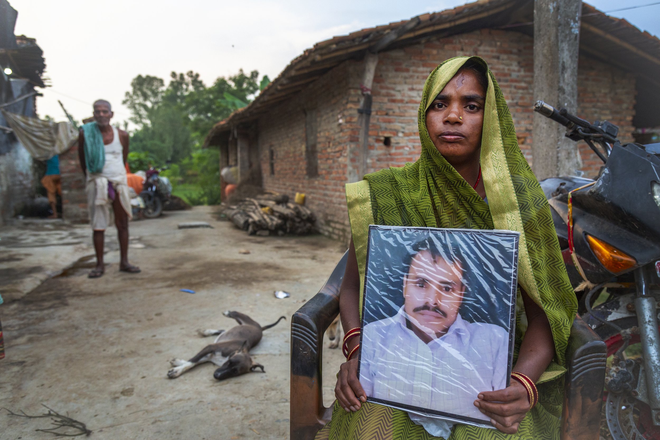  Manju Devi Mandal, 38, holds a portrait of her husband, Kripal Mandal, in the village of Nagrain 9, in the Ghodhas District outside of Janakpur, Nepal on July 1, 2022.   Her husband died at age 40 of a heart attack in Qatar.   Her brother-in-law is 