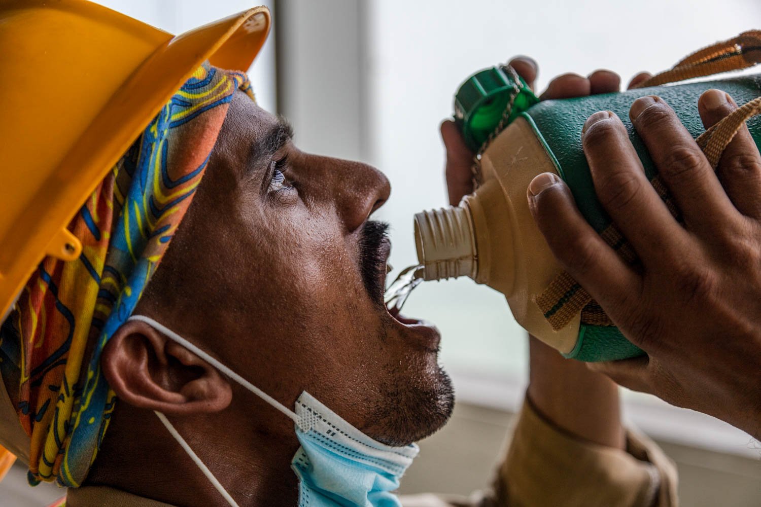  A worker drinks water at a construction site in Doha, Qatar on August 17, 2022. 