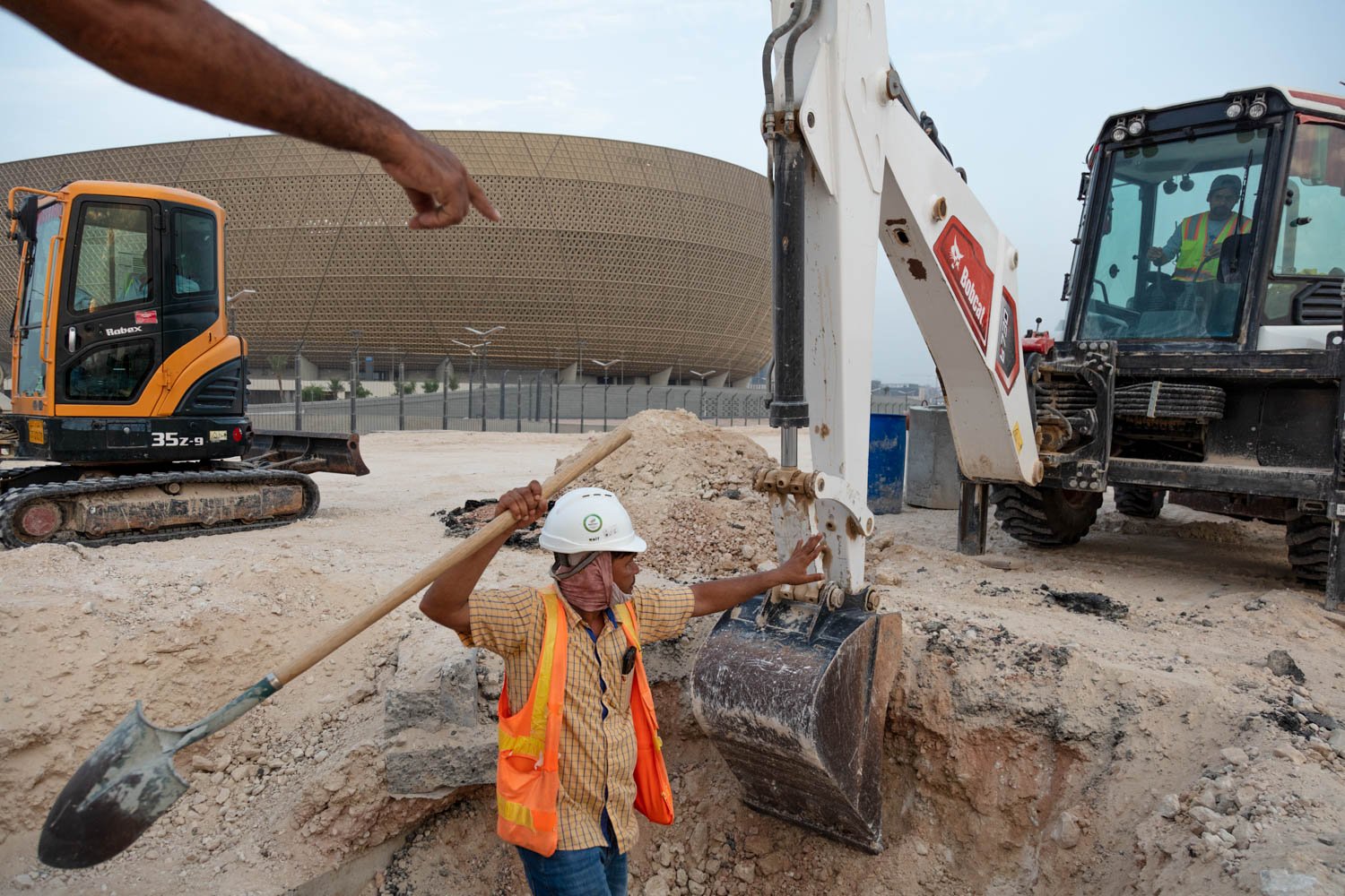 Workers put the finishing touches on the surrounding landscape of the main World Cup stadium in the Lusail area of Doha, Qatar on August 17, 2022. 