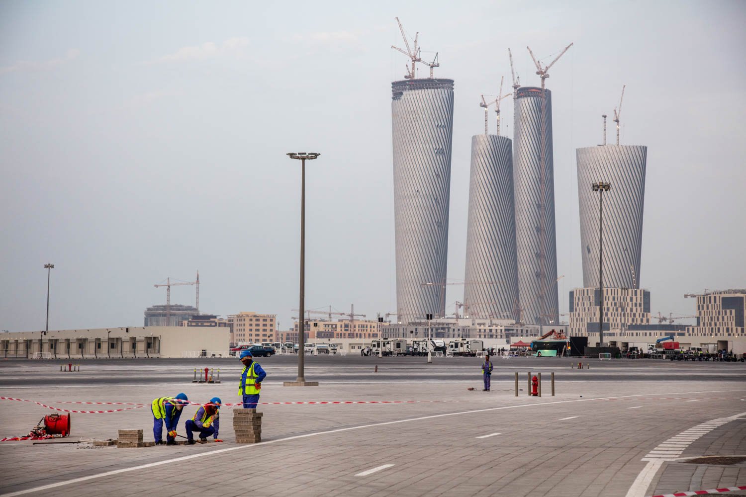  Workers put finishing touches on the surrounding landscape of the main World Cup stadium in the Lusail area of Doha, Qatar on August 17, 2022. 