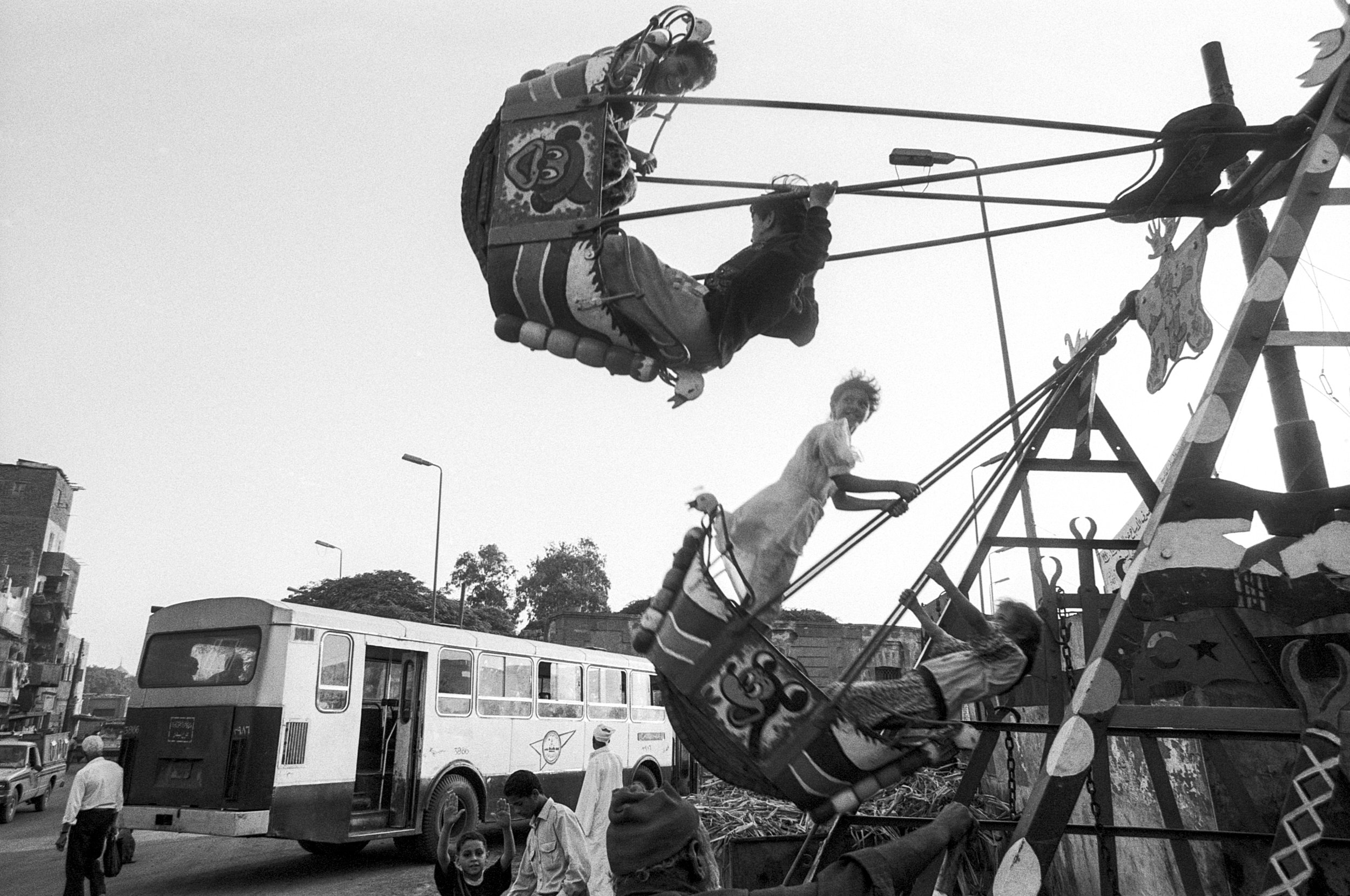  Kids play on an amusement park ride in the City of the Dead. 