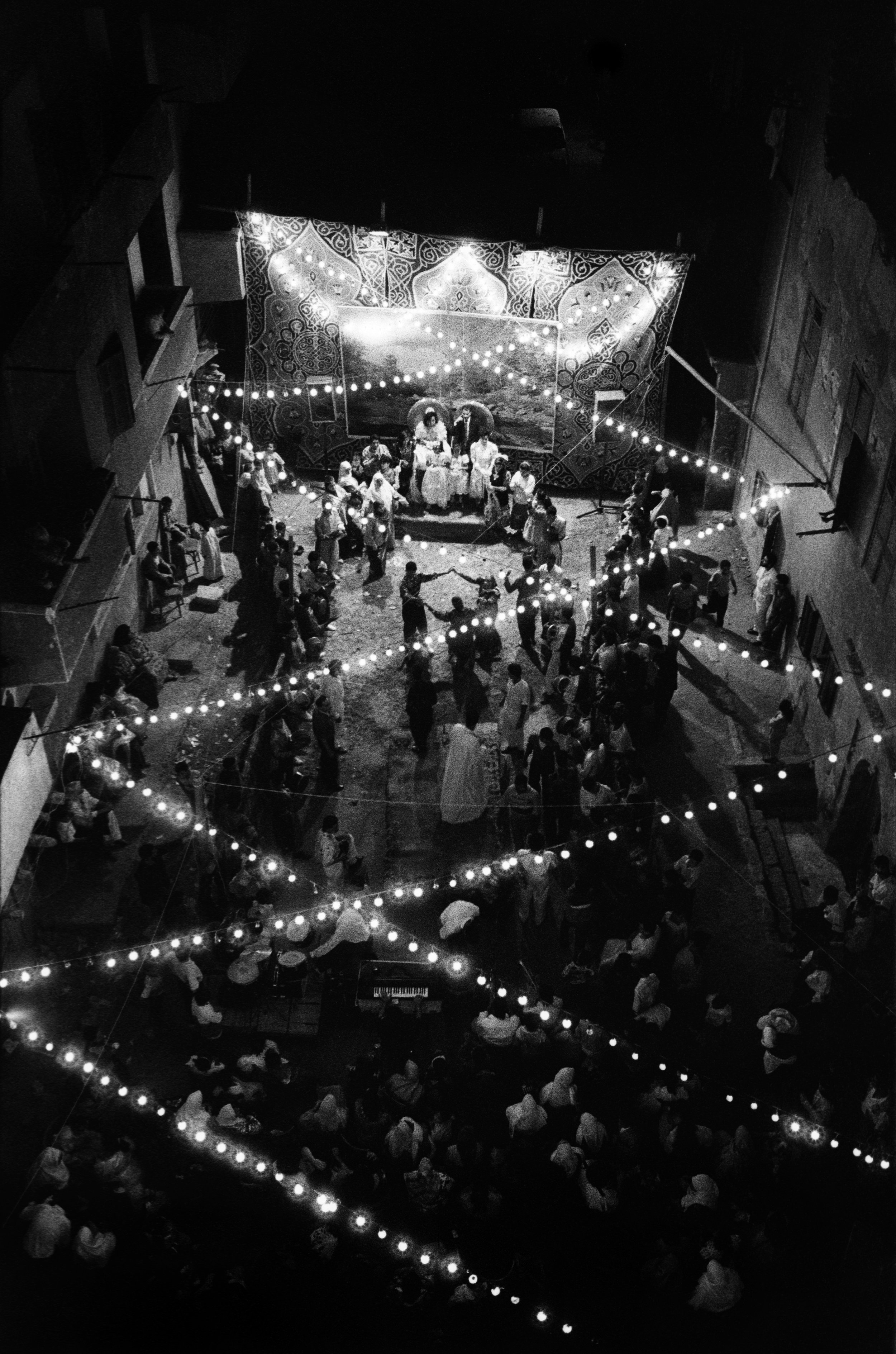  An overview of an evening wedding ceremony in the street between mausoleums. 