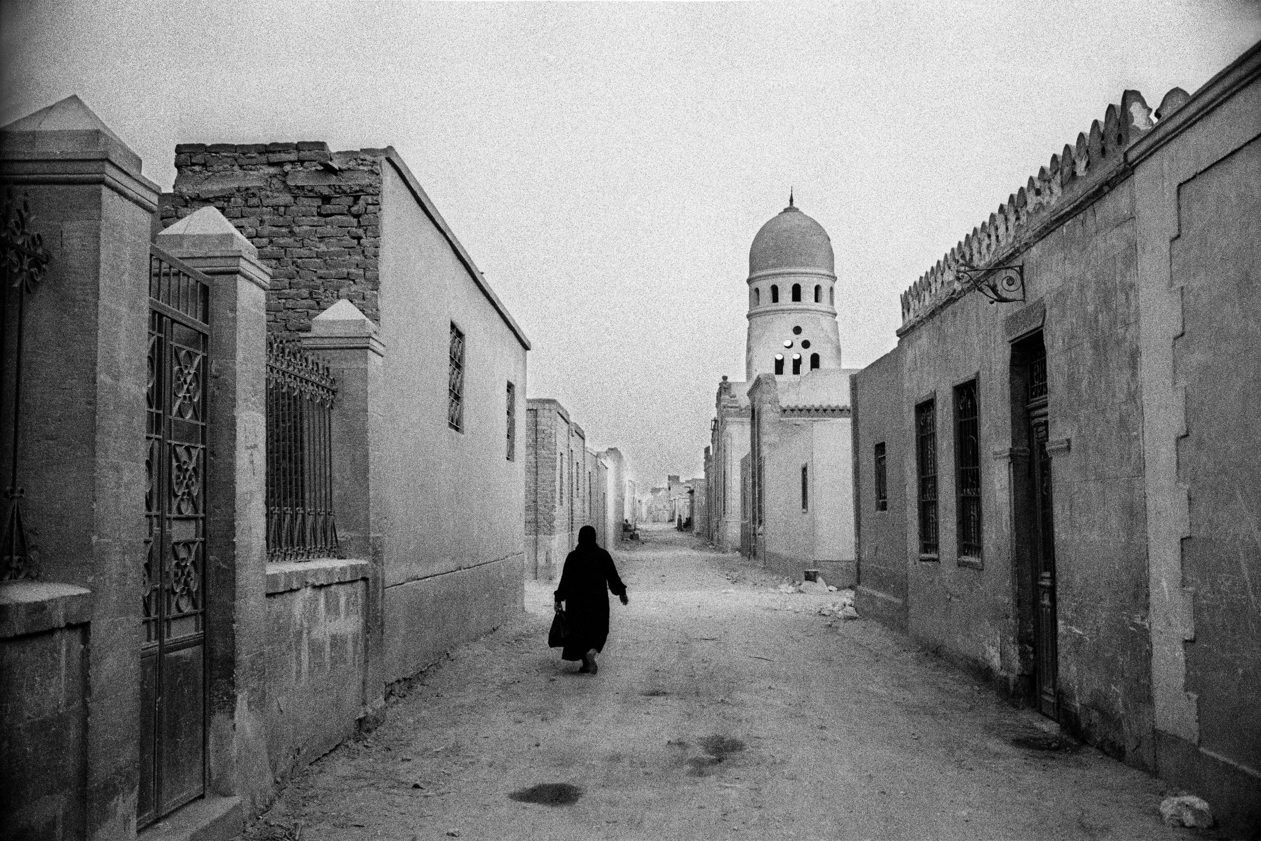  A lone woman walks the alleyways in the City of the Dead. 