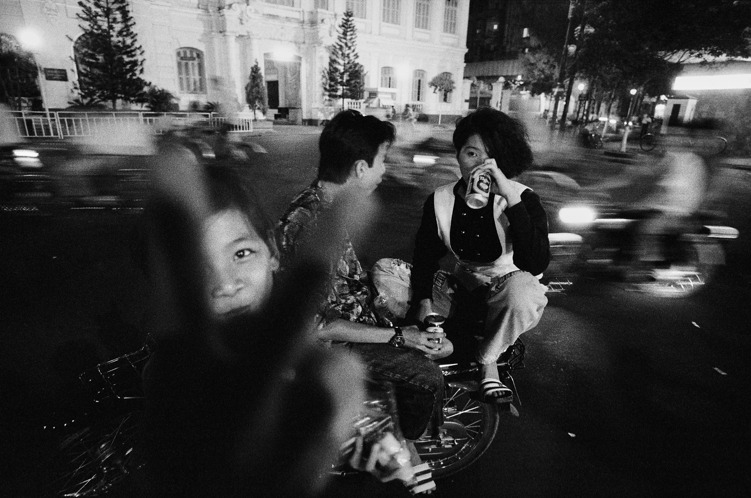  Cruising the city streets of downtown Saigon at night has become a ritual for young people. These teenagers drink beer in front of City Hall. 