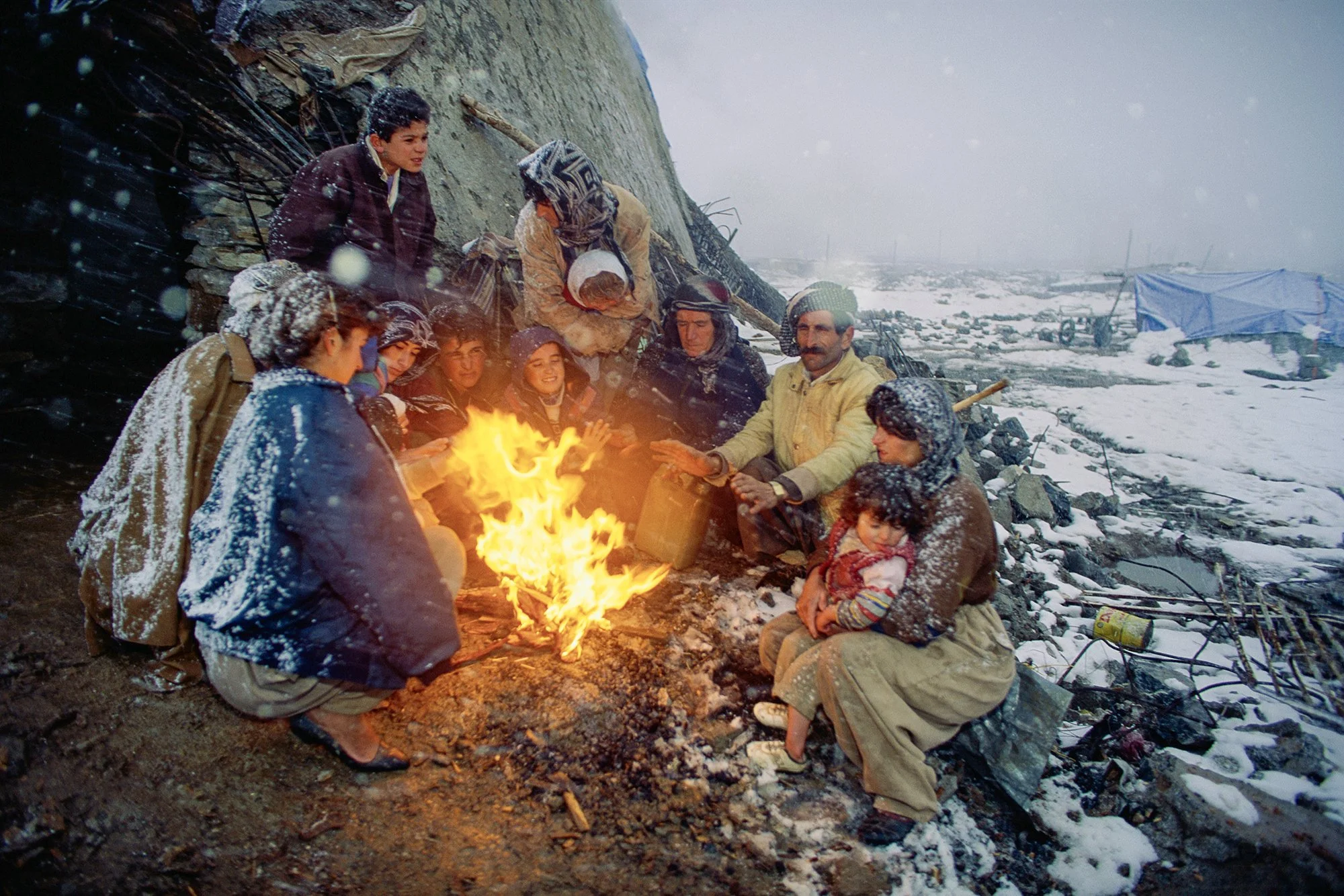 Having fled their war-torn home near Kirkuk, Iraq, a Kurdish family battles the elements in the ruins of Penjwin, Iraq, 1991.