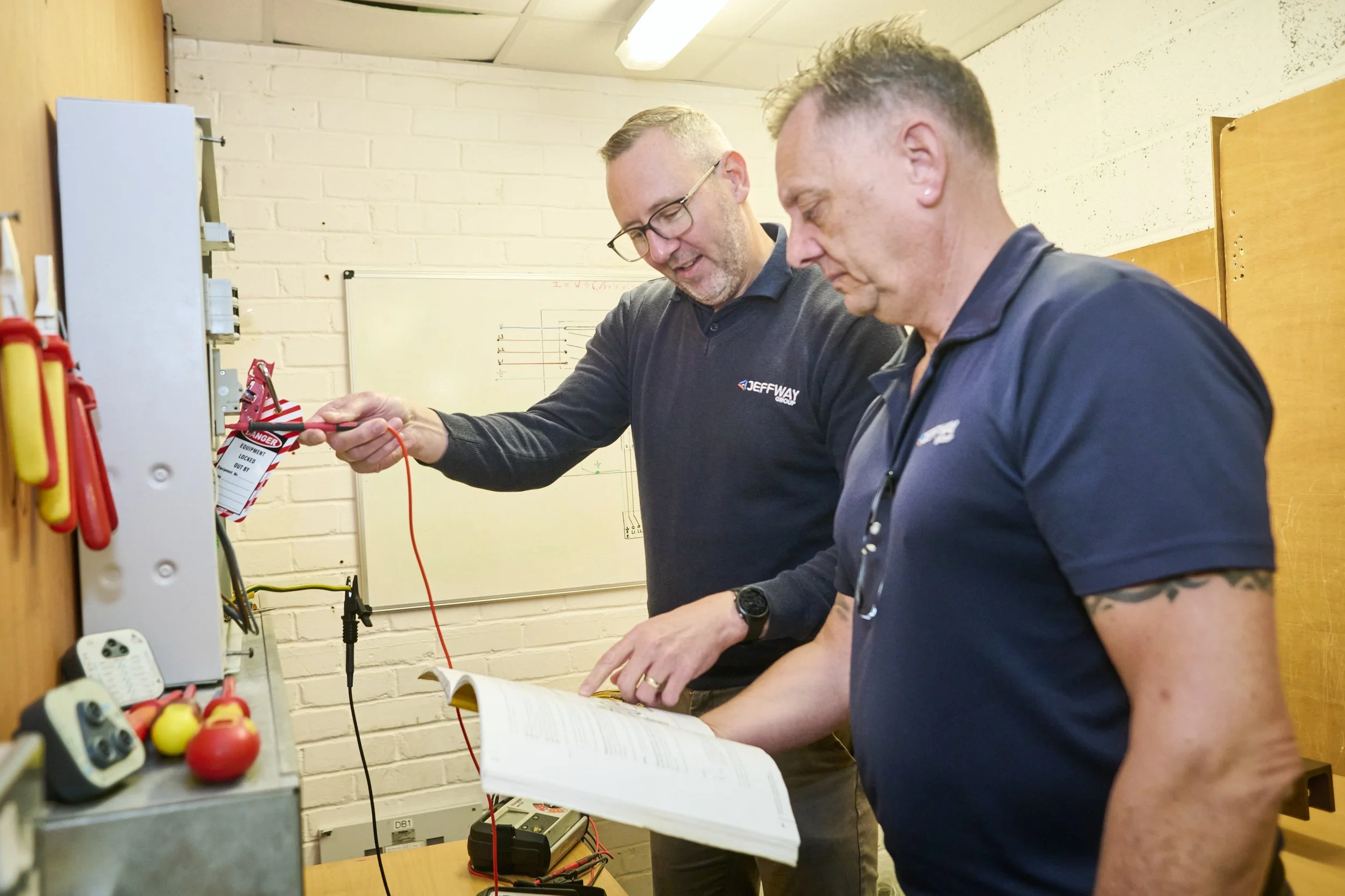Jeff Way Group trainer guiding an apprentice at an electrical test board
