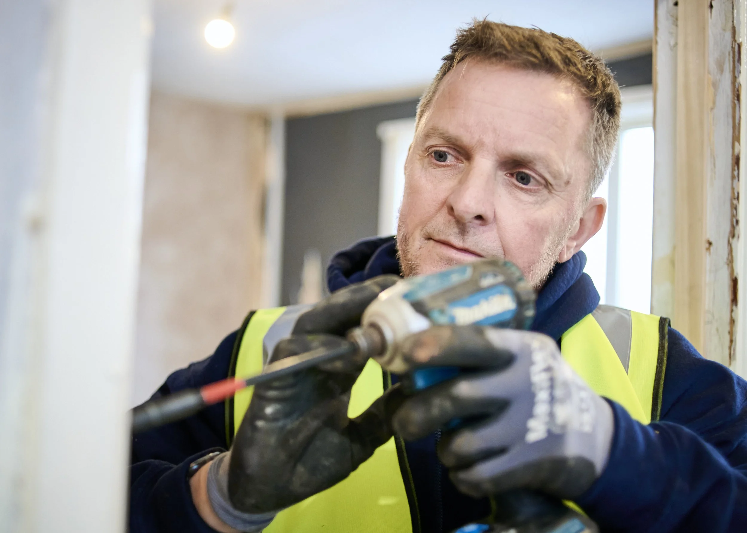 Jeff Way Group engineer in protective gloves using a power drill