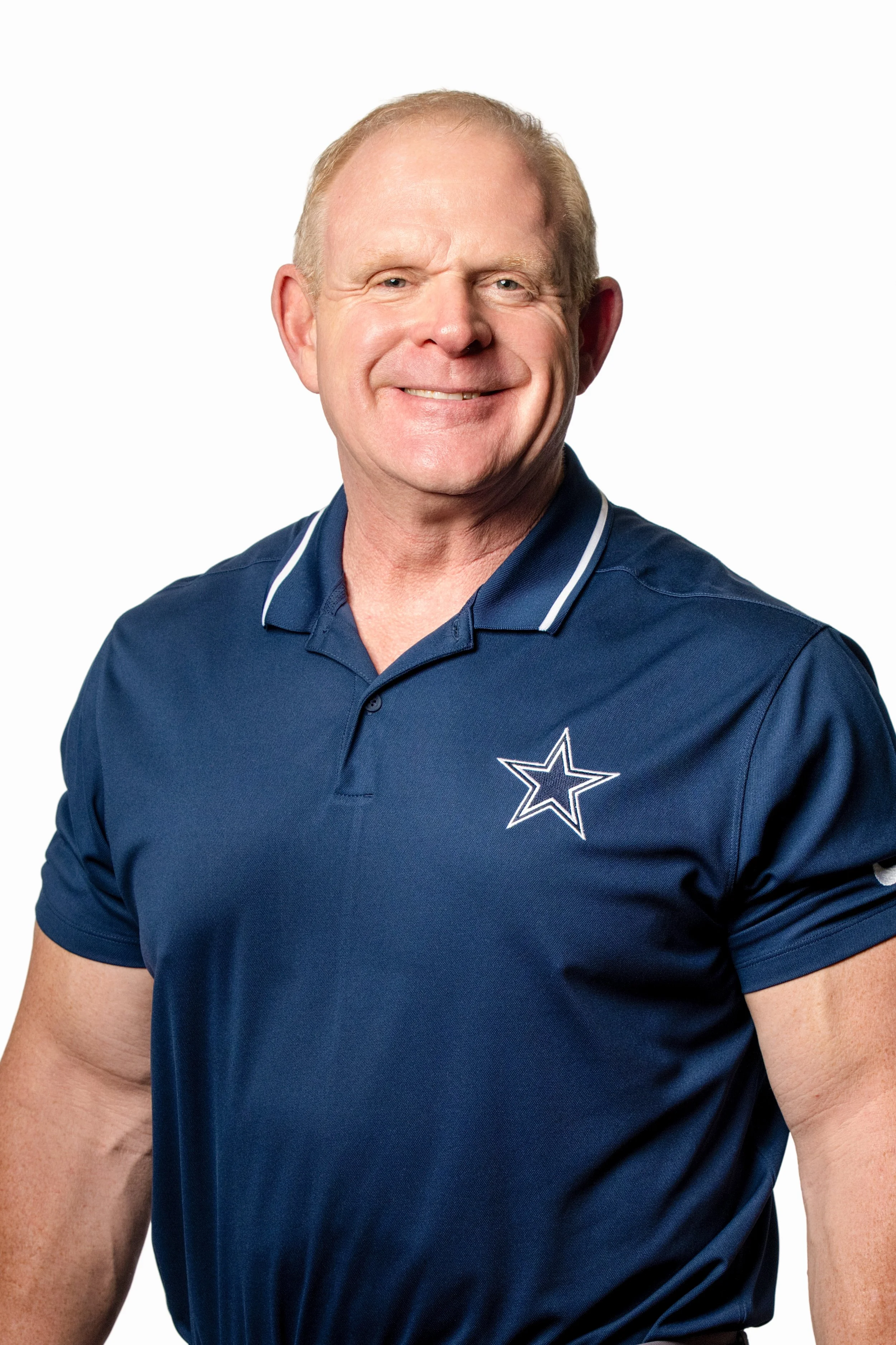 Professional headshot of Dr. Fred Casper, Doctor of Chiropractic, smiling in a navy Dallas Cowboys polo shirt, shown alongside his professional biography and credentials on a clean, neutral website layout.