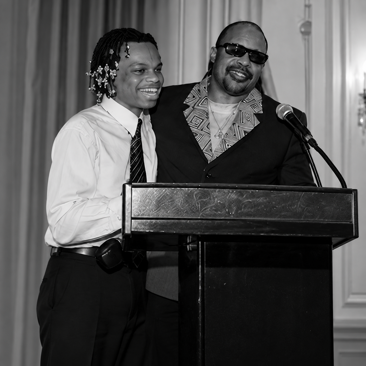 Two people smiling together behind podium at event.png