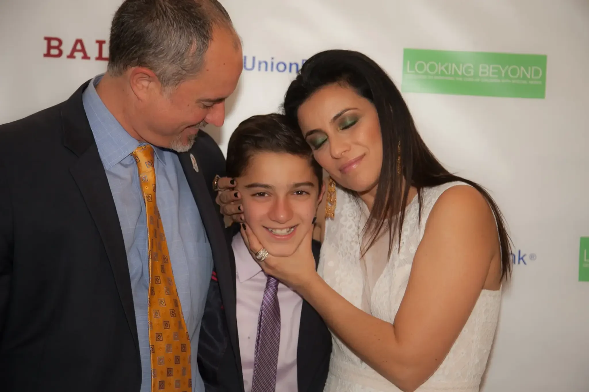 12-family-portrait-at-sponsor-wall.webp