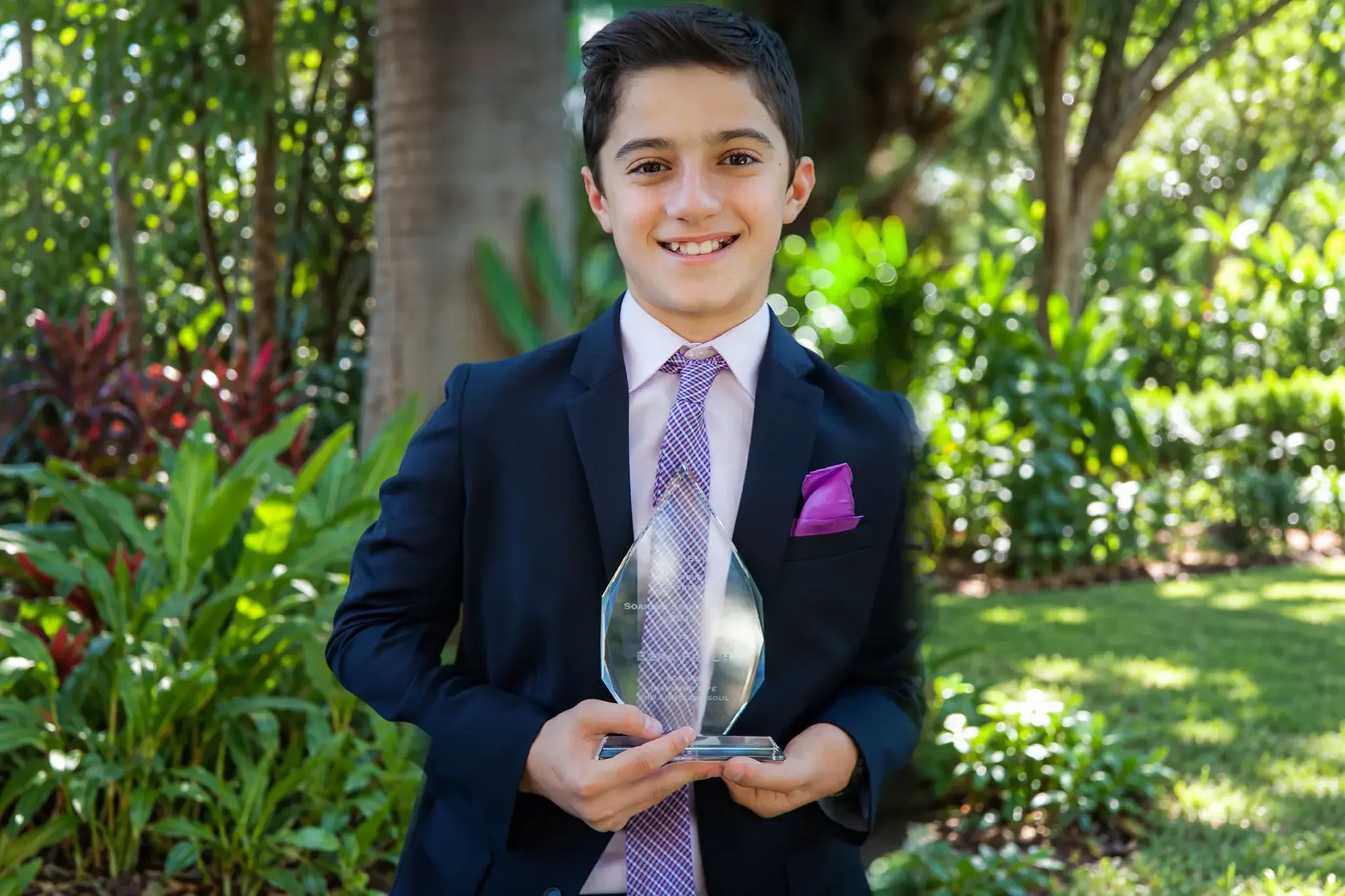 10-boy-holding-award-outdoors.webp
