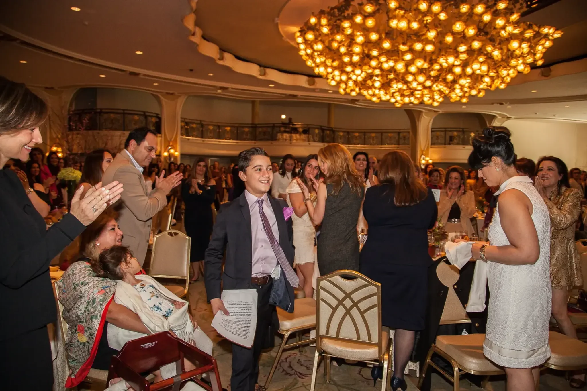 11-boy-among-applauding-guests.webp