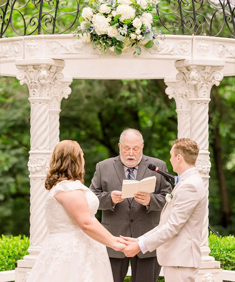 Bride and groom exchanging vows during their outdoor wedding ceremony in St. Louis.