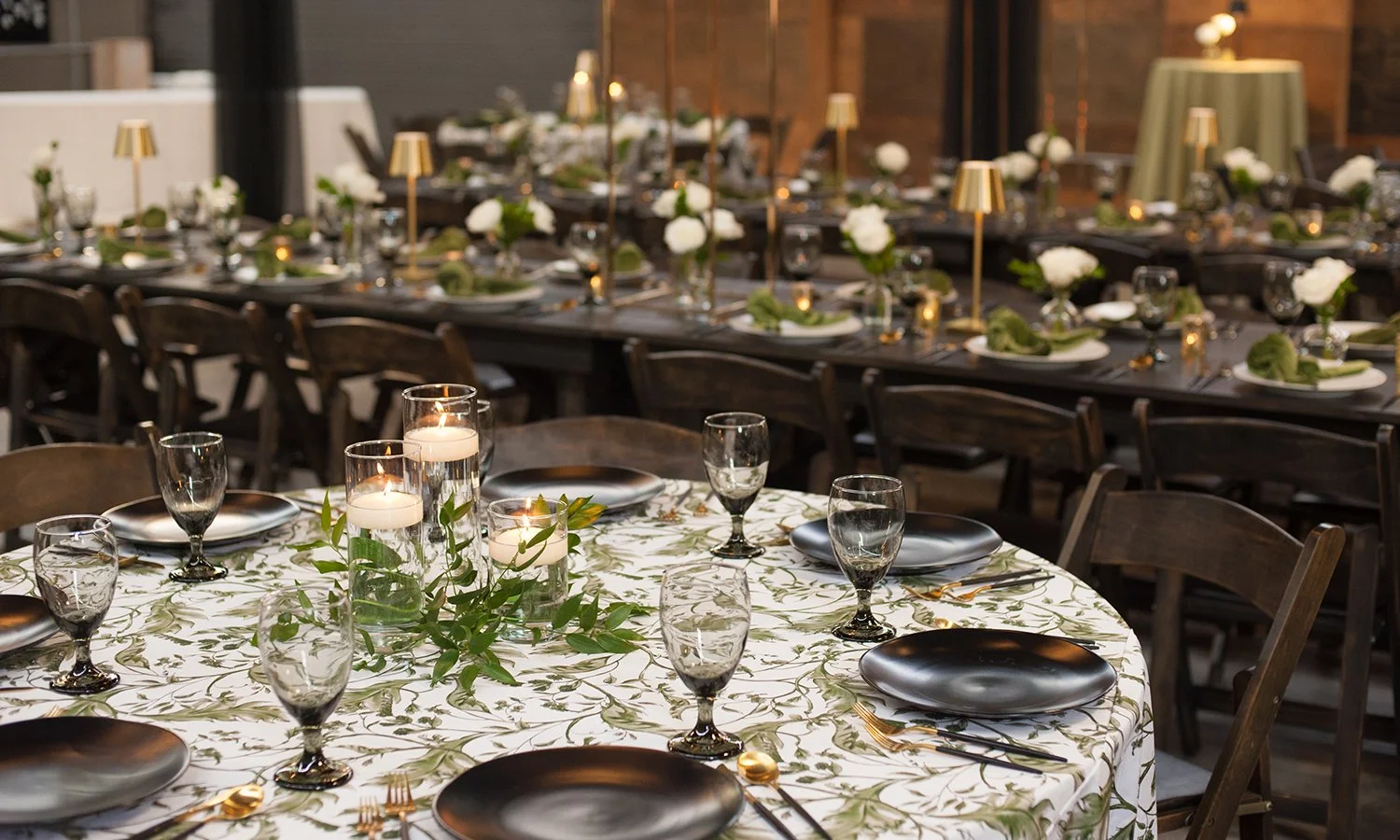 Floating candles with greenery on a rehearsal dinner table in St. Louis.