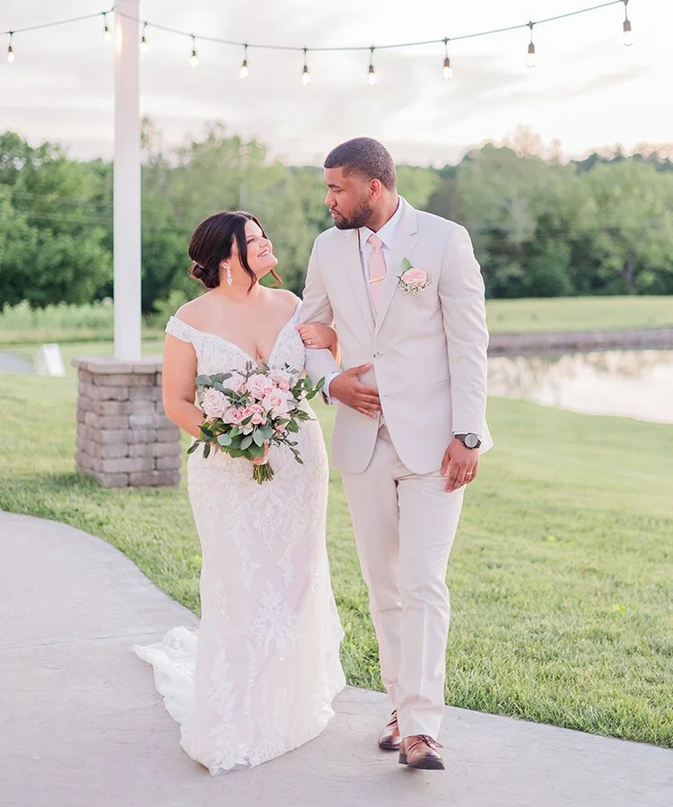 Bride and groom walking while holding a Blush Garden Bridal bouquet designed by St. Louis florist, The Flower Lab.