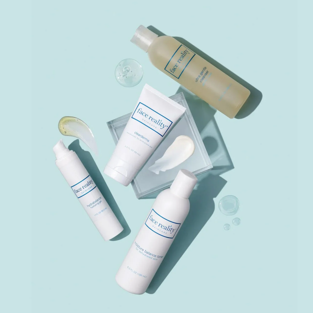 Skincare products including cleansers, toners, and serums from Face Reality, displayed on a light blue background with smears and droplets of product.