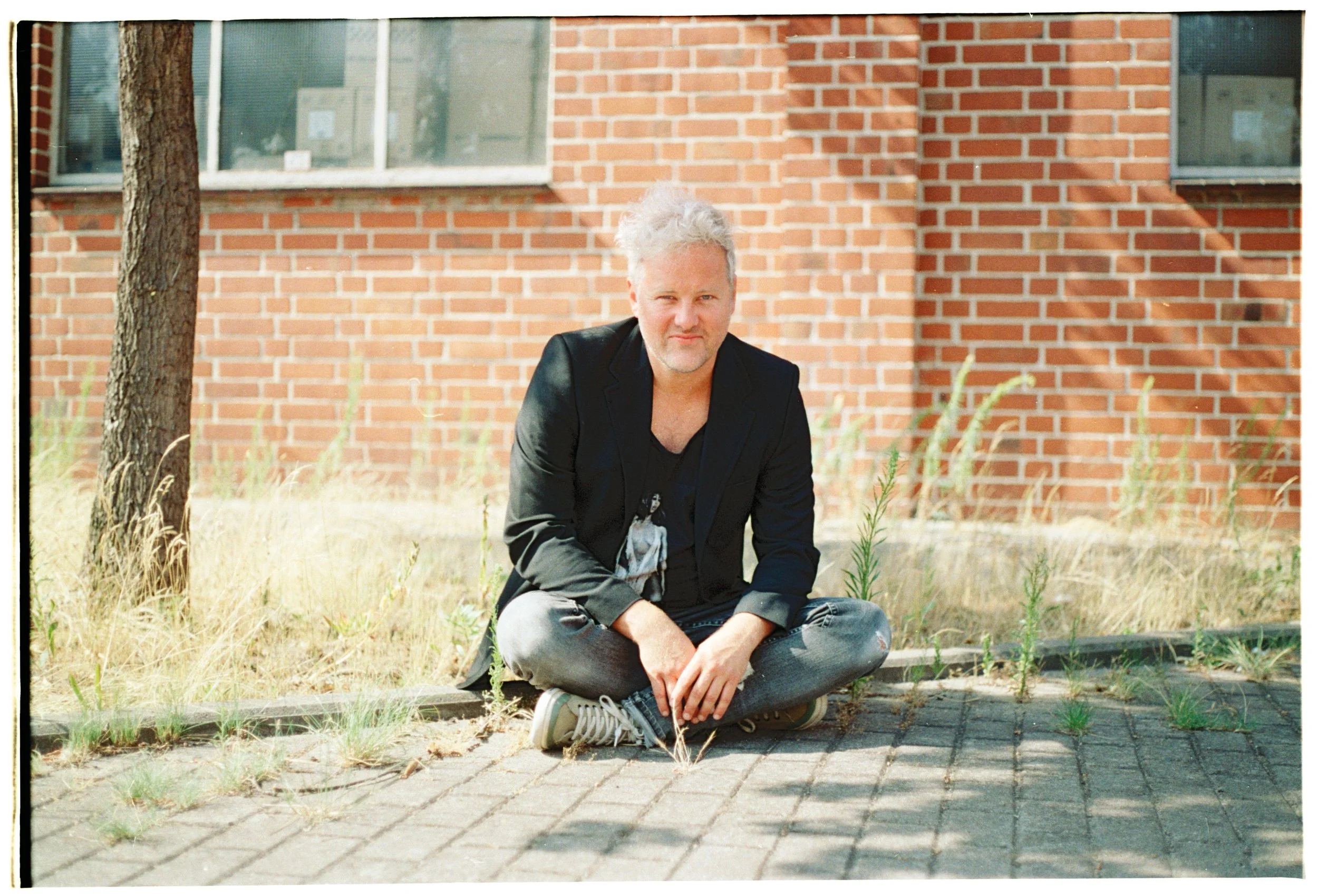 Philip Richert sitzt auf Bordstein