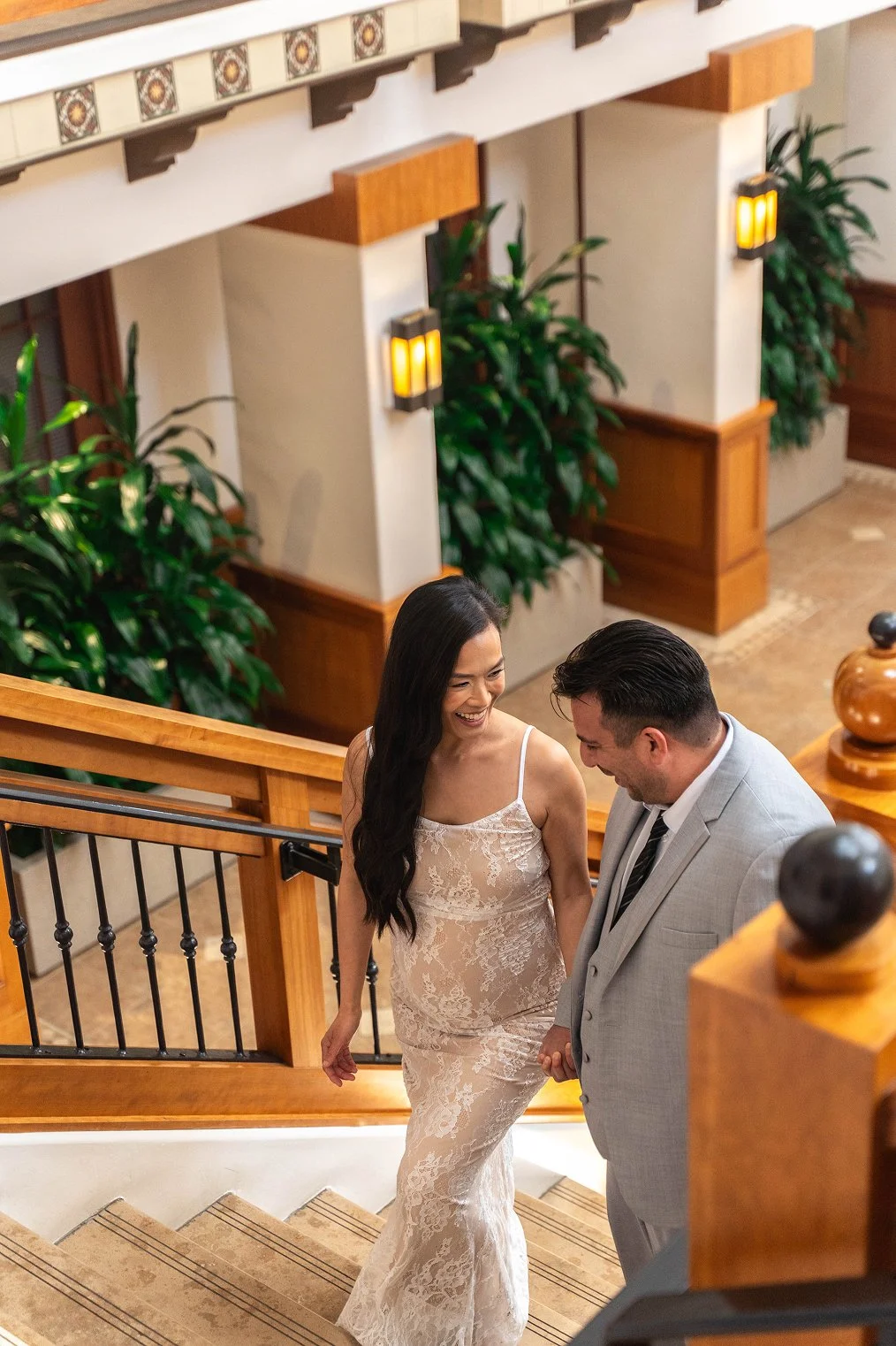 A couple smiles while walking upstairs for their Laguna Hills Civic Center wedding photos.