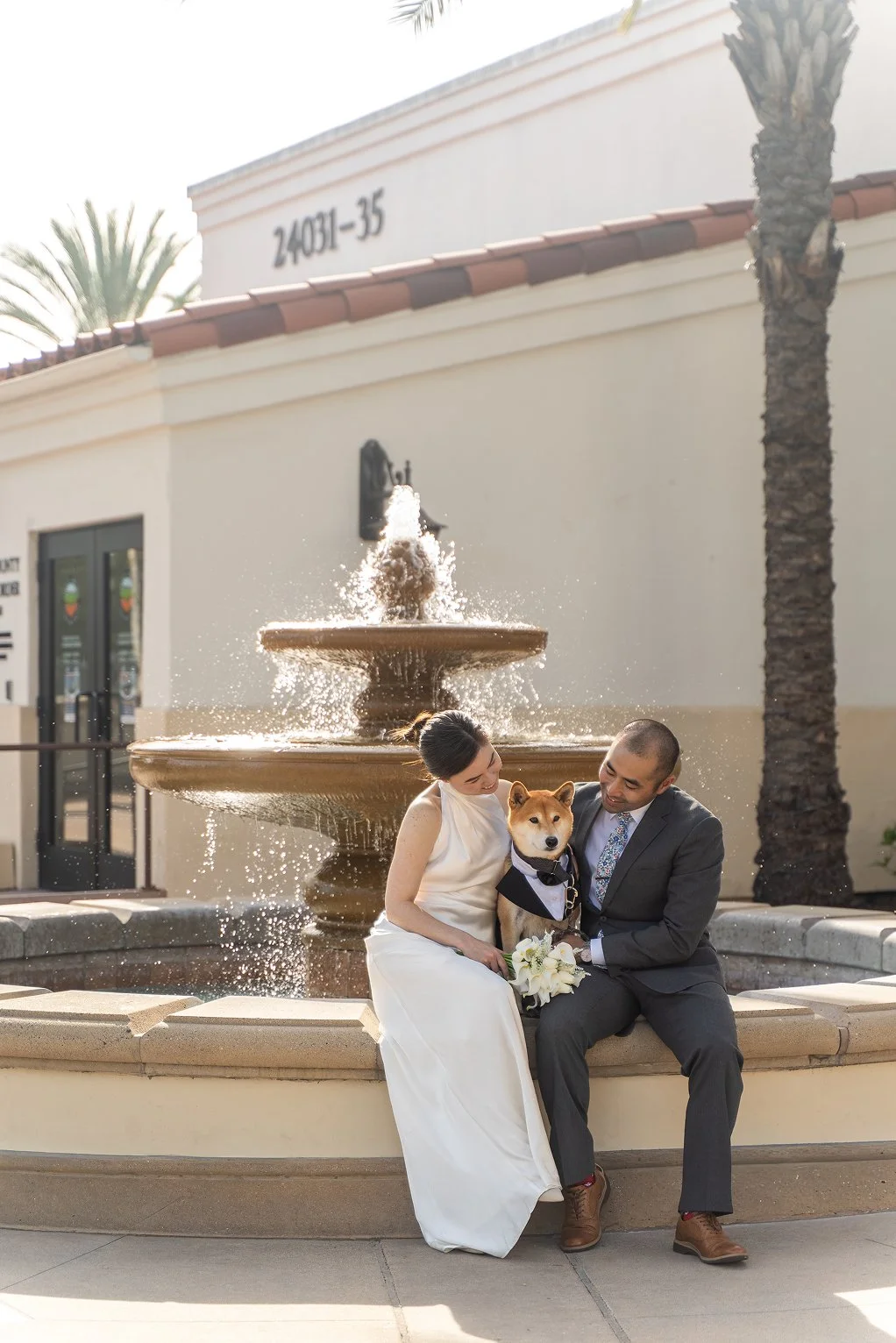A couple poses with their dog for their Laguna Hills Civic Center wedding photos.