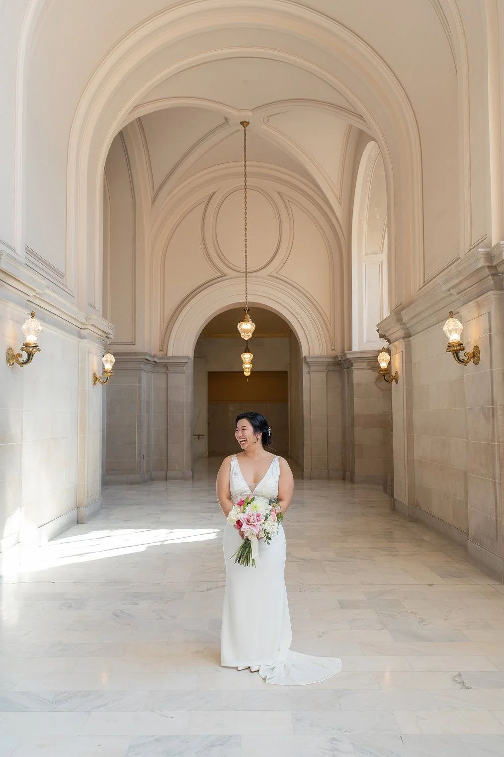 Bride laughs while taking San Francisco City Hall wedding photos