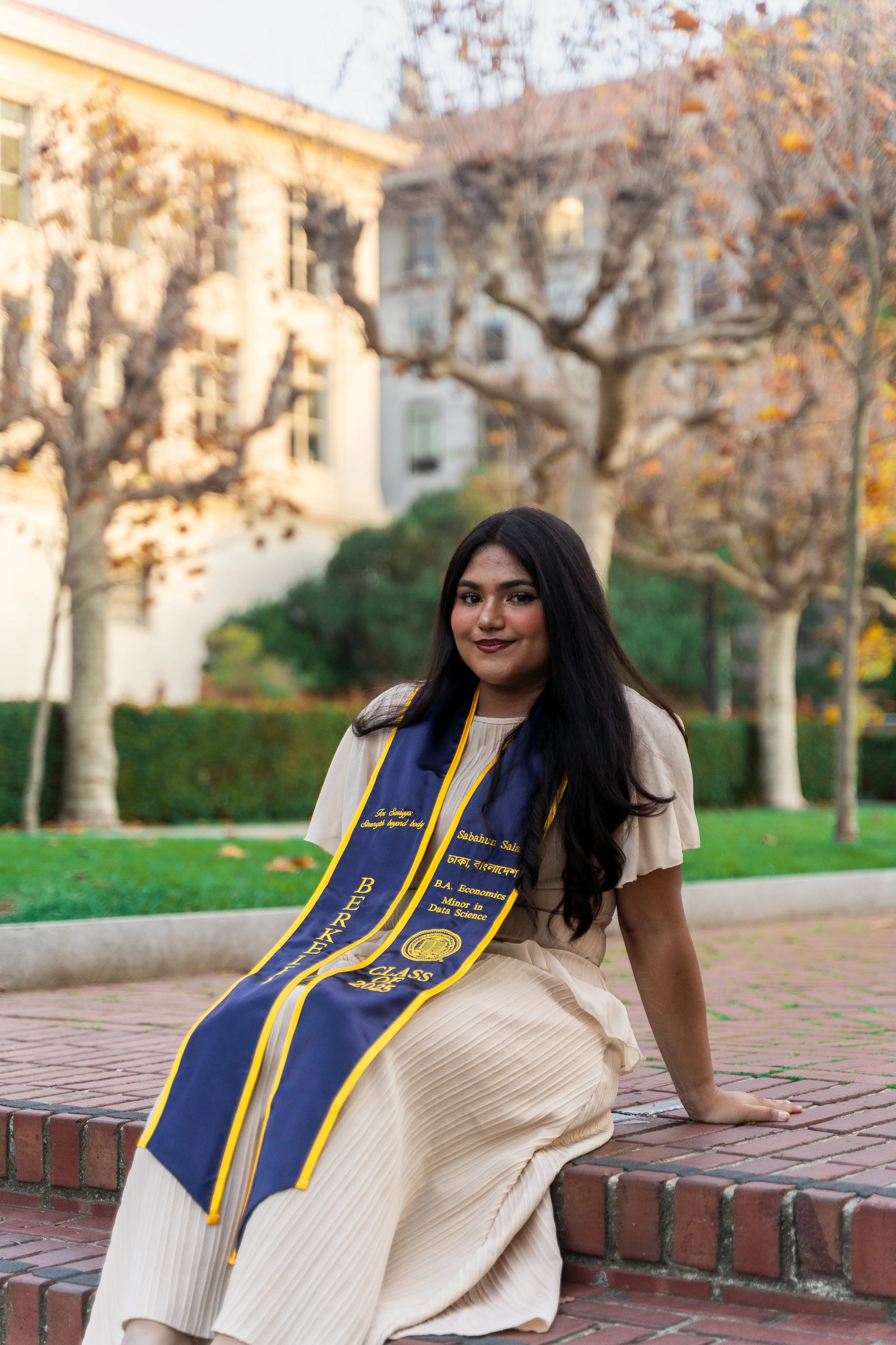 UC-Berkeley-grad-poses-for-photo-by-Campanile