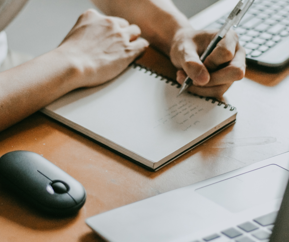 Person arbeitet am Laptop mit Notizbuch – Symbolbild für die Erstellung eines modernen Lebenslaufs