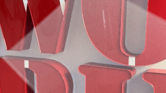 Close-up of a red metal sign with cut-out letters.