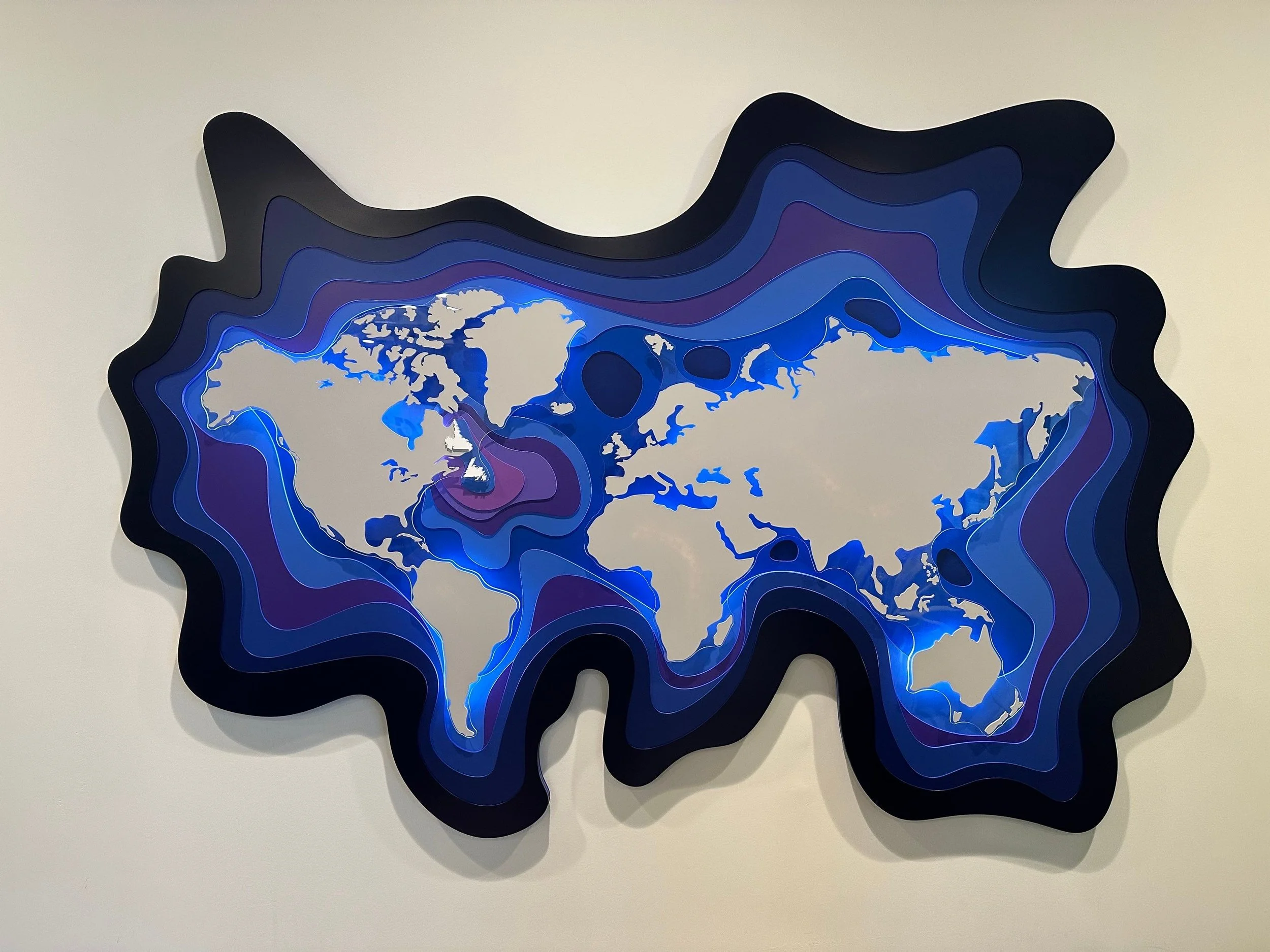 Colorful layered paper map of the world with contour lines.